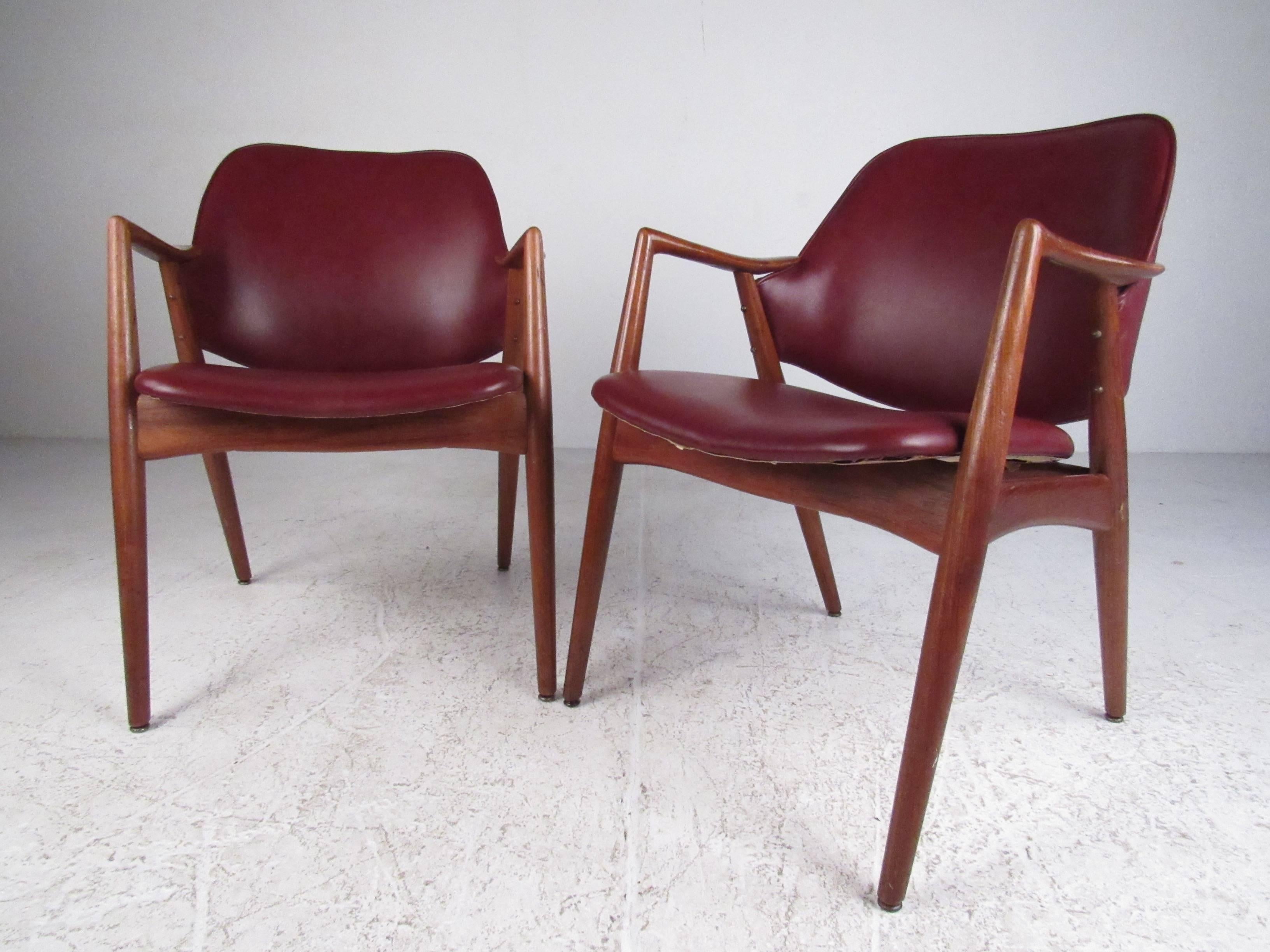 Stylish pair of teak and vinyl midcentury armchairs in the manner of Erik Kirkegaard. Please confirm item location (NY or NJ) with dealer.