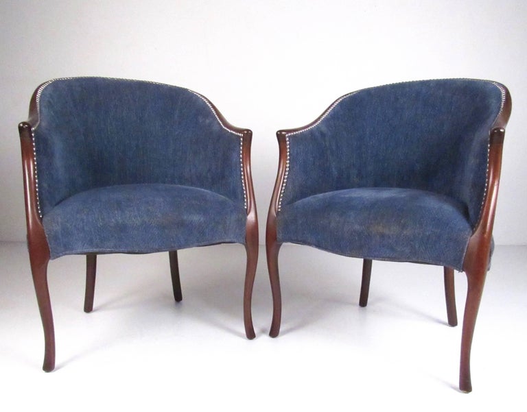 Pair of American baker style side chairs make a comfortable and stylish addition to any home or office seating area. Club seats boast shapely wooden frames with carved details as well as studded upholstery. Please confirm item location (NY or NJ).