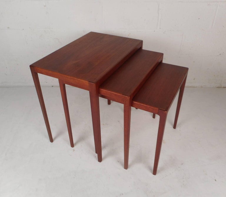 This beautiful set of three vintage modern stacking tables are designed by Ludvig Pontoppidan. The sleek design allows these lovely tables to sit comfortably on top of each other. Unique pieces with long tapered legs and a smooth vintage teak