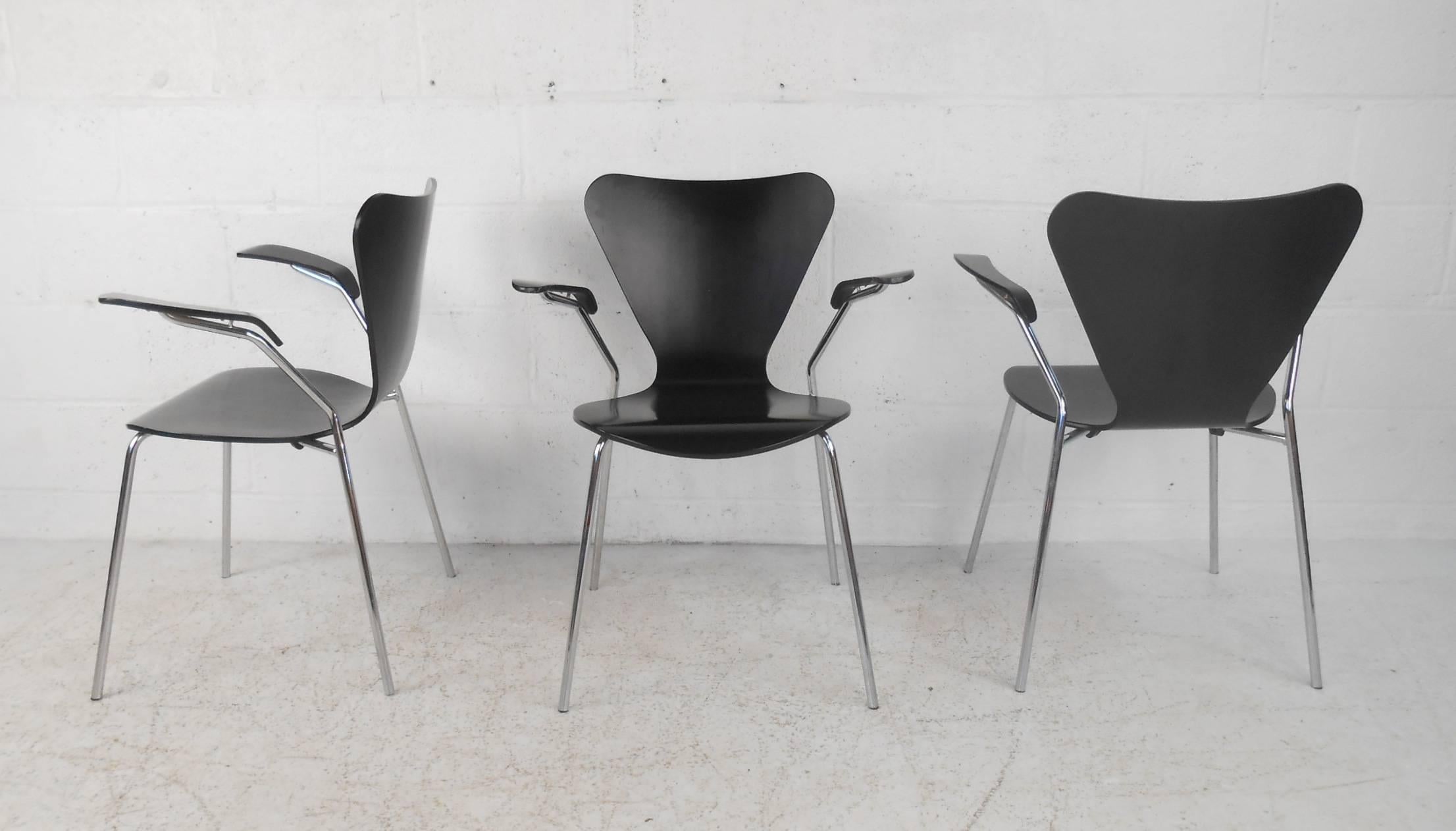 This beautiful vintage modern set of three chairs feature unique winged back rests, high arm rests, and bent rod chrome frames. Sleek design has bent black wood seating with the perfect contours ensuring maximum comfort. Unusual angled arm rests and