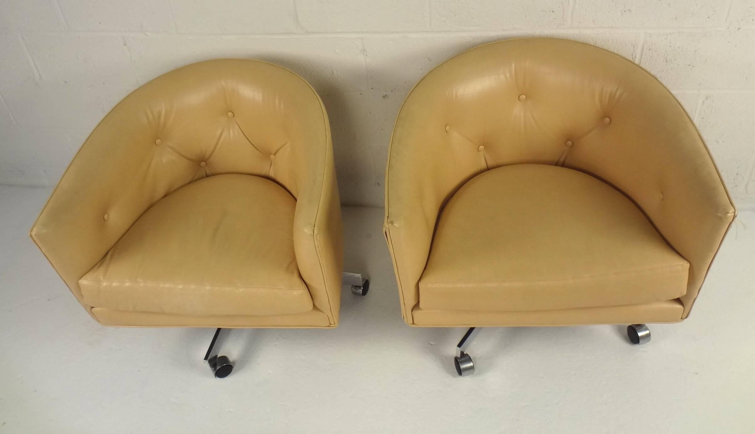 This beautiful pair of vintage lounge chairs by Milo Baughman feature the ability to swivel and have a super supportive wraparound barrel backrest. Sleek design with a subtle embossed gatorskin on the faux leather covering and wide seating. A chrome