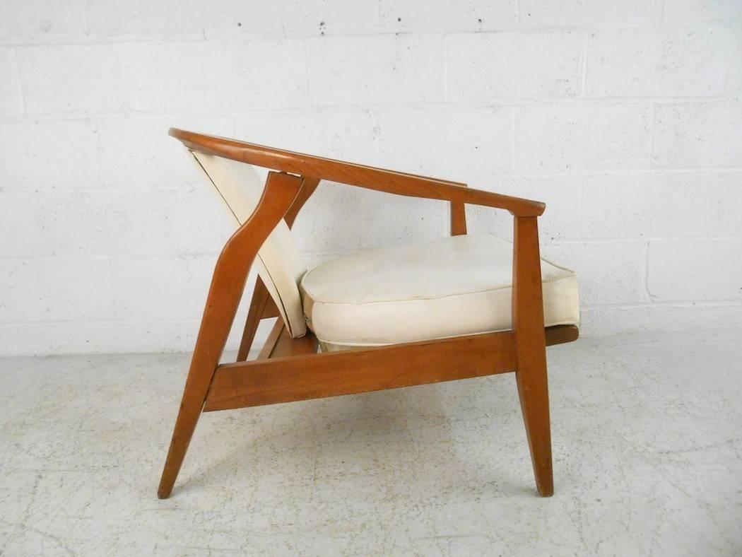Dieser schöne moderne Loungesessel im Vintage-Stil hat eine einzigartige, nach unten geneigte Rückenlehne. Dieser Kapitänsstuhl hat abgewinkelte Rückenlehnen und dick gepolsterte Sitzflächen, die mit weißem Vinyl bezogen sind. Dieses ungewöhnliche