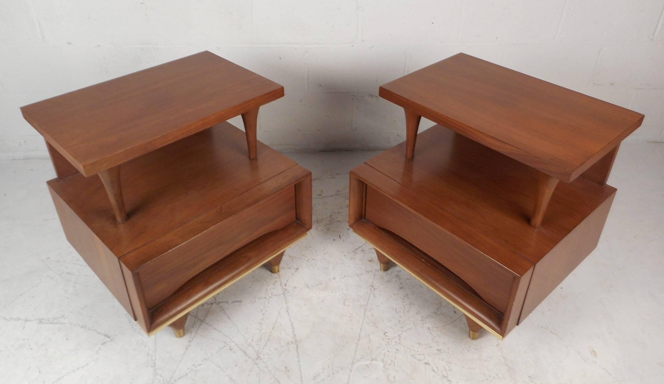 This beautiful pair of vintage modern nightstands feature a floating style top with sculpted supports. Unique design with brass trim along the base and brass capped feet. One large drawer with a recessed ellipse pull offers plenty of room for