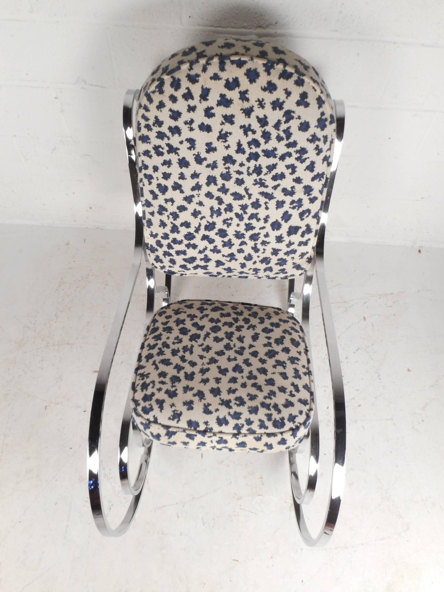Dieser schöne moderne Schaukelstuhl im Vintage-Stil verfügt über ein schweres Chromgestell mit Flachstangen und gepolsterter Sitzfläche. Der stilvolle weiß-blaue Stoff über der dick gepolsterten Sitzfläche sorgt für maximalen Komfort. Das geformte