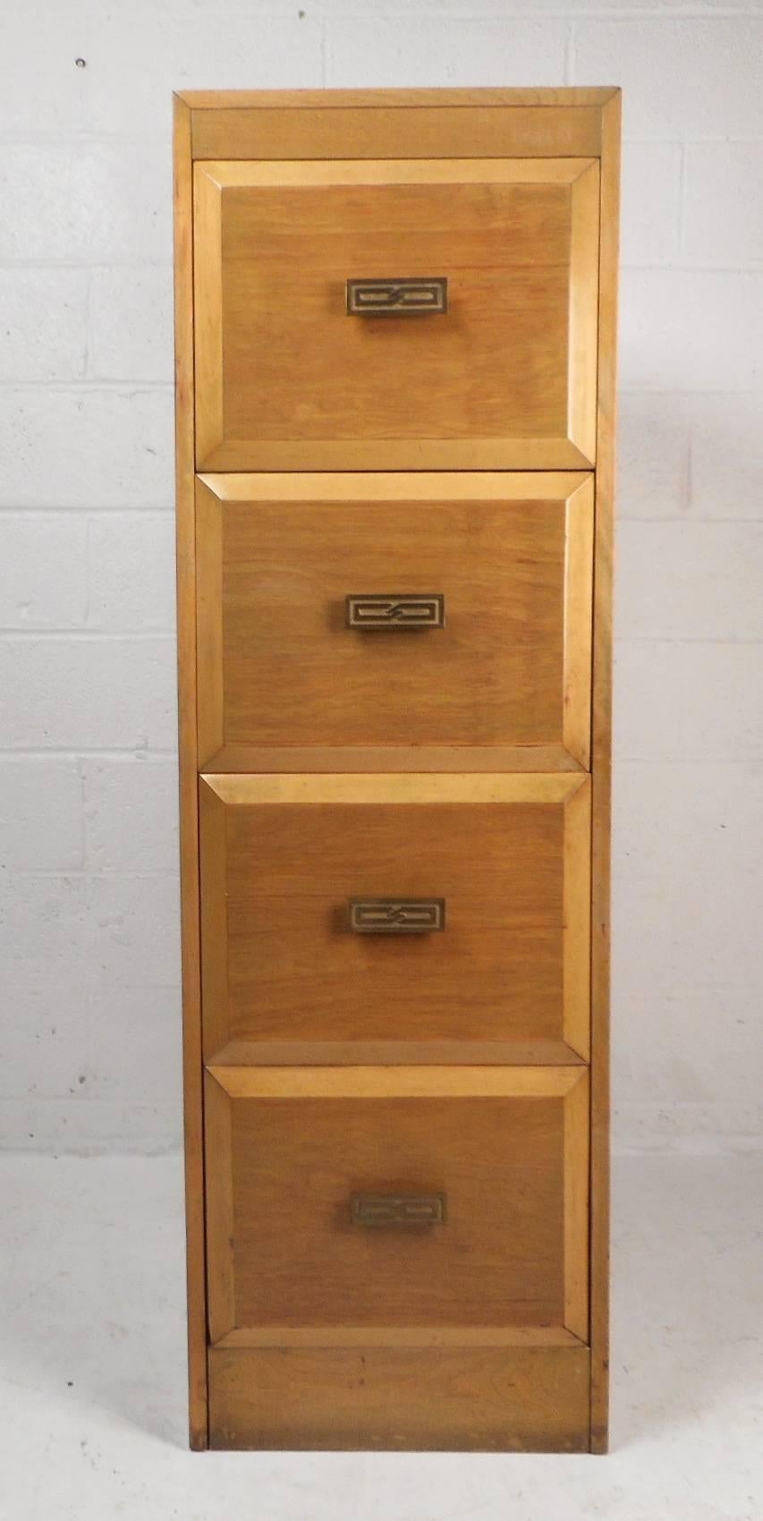 This beautiful vintage modern file cabinet features four large drawers with wooden dividers in each to separate items or documents. This wonderful case piece has unique sculpted drawer pulls with a carved design on each. This impressive high chest