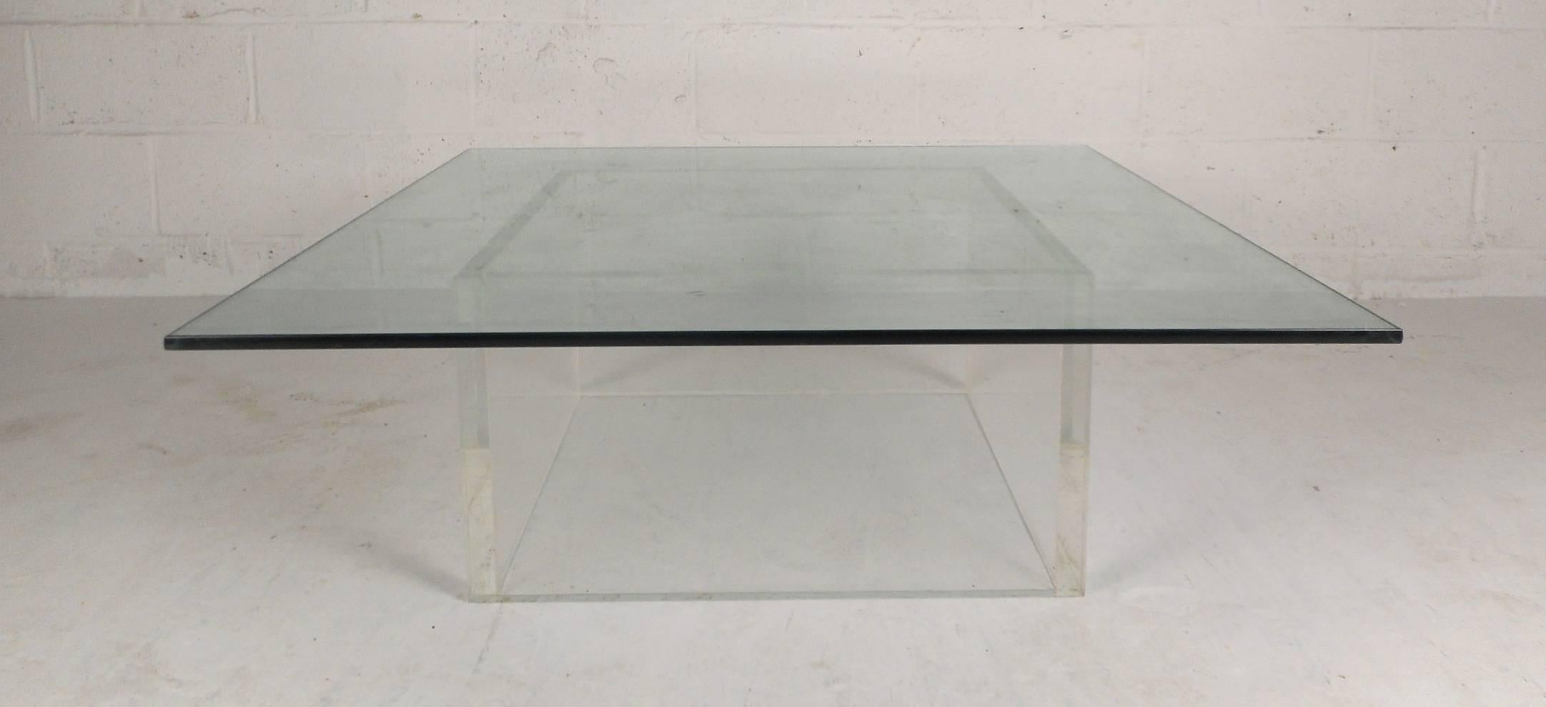 This gorgeous vintage modern coffee table features a unique Lucite base with a square glass top. Sleek design with extremely thick glass adding to the allure. This wonderful midcentury piece is sure to add style and grace to any modern interior.