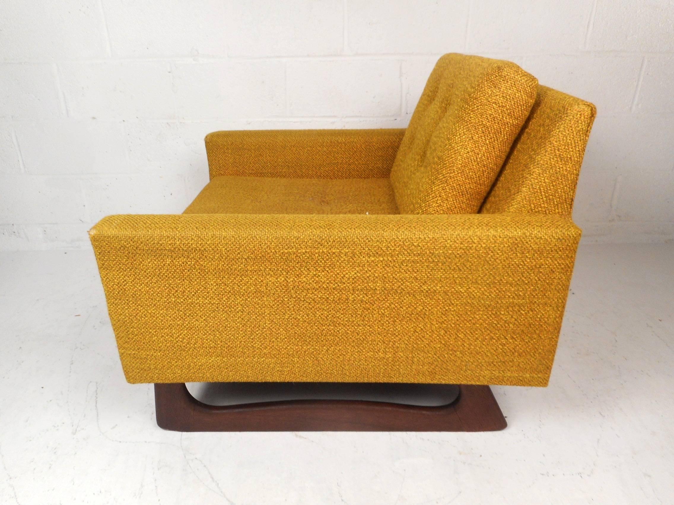 This beautiful vintage modern lounge chair features plush yellow upholstery and a sculpted walnut sled base. Sleek design with overstuffed removable cushions and a tufted fabric adding to the midcentury appeal. The wide seating and low arm rests