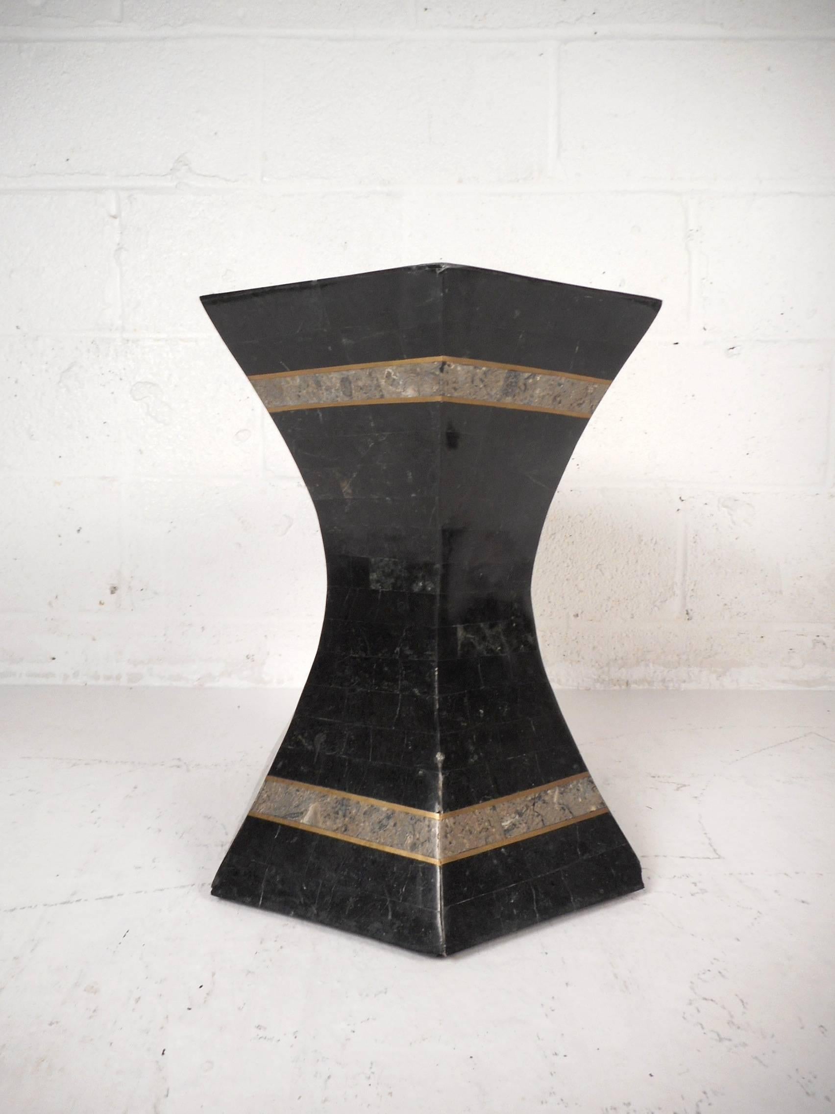 This gorgeous vintage modern set of three pedestal tables feature sleek black tesselated stone with brass inlays. Wonderful two-tone design with a sculpted body and beveled edges adding to the allure. This unusual mid-century set can be used as side