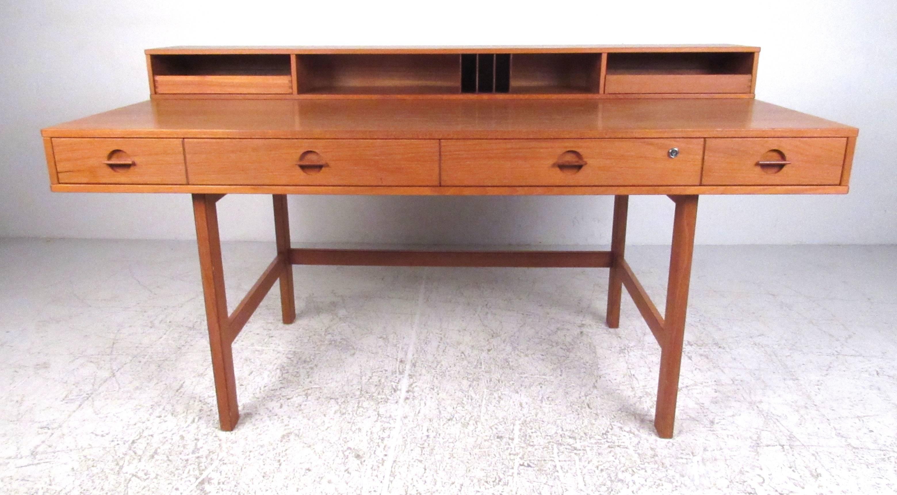 An expandable Danish modern desk designed by Jens Quistgaard of Dansk for Peter Løvig Nielsen, circa 1970s. With a generous work surface and low profile cubbies and storage trays, it can easily convert to a partners desk or conference table, while