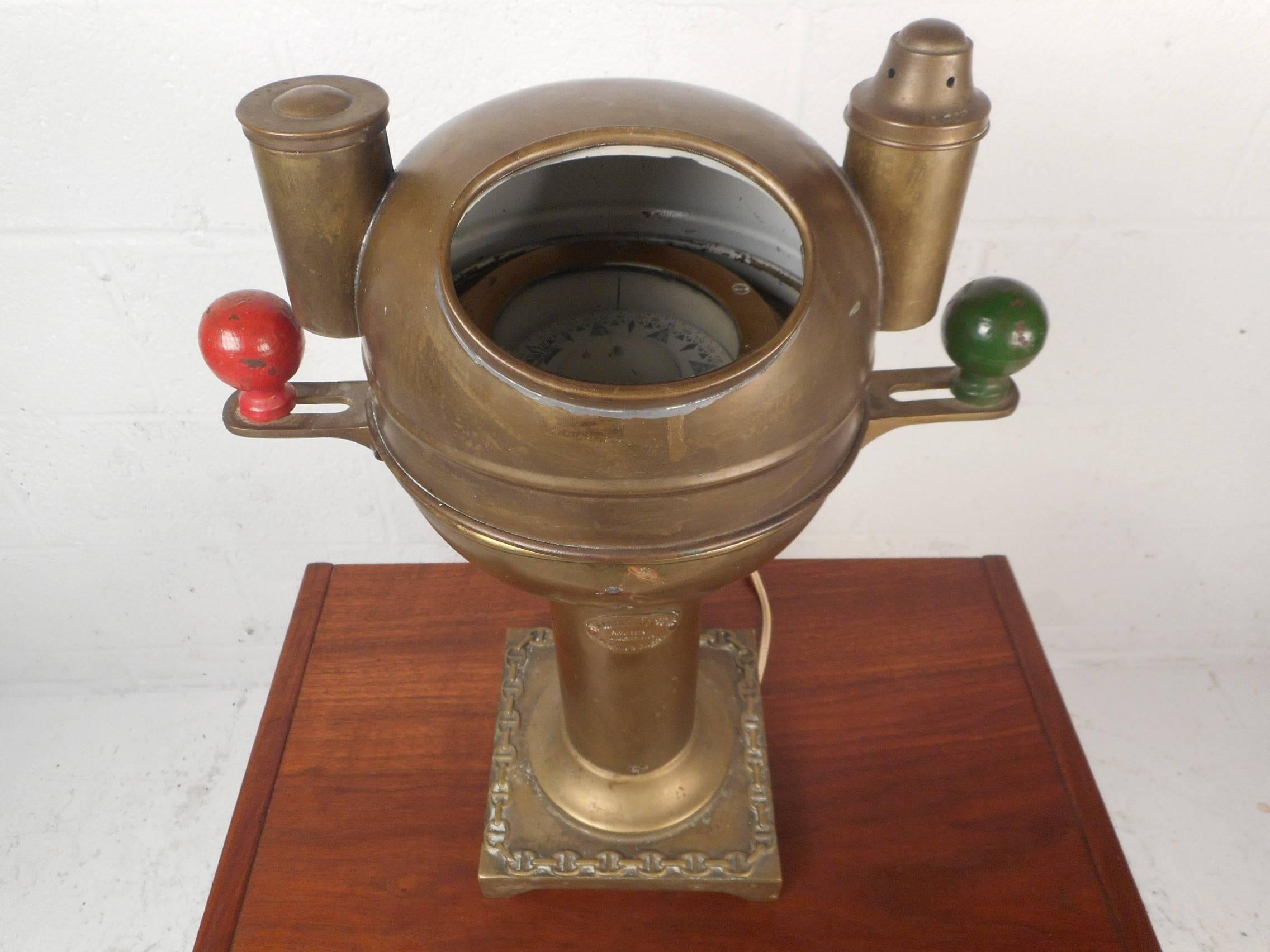This stunning antique brass binnacle compass makes the perfect nautical decoration in any home, business, or office. This beautiful piece has a removable top with a small light bulb inside meant to illuminate the interior enough to see the compass.