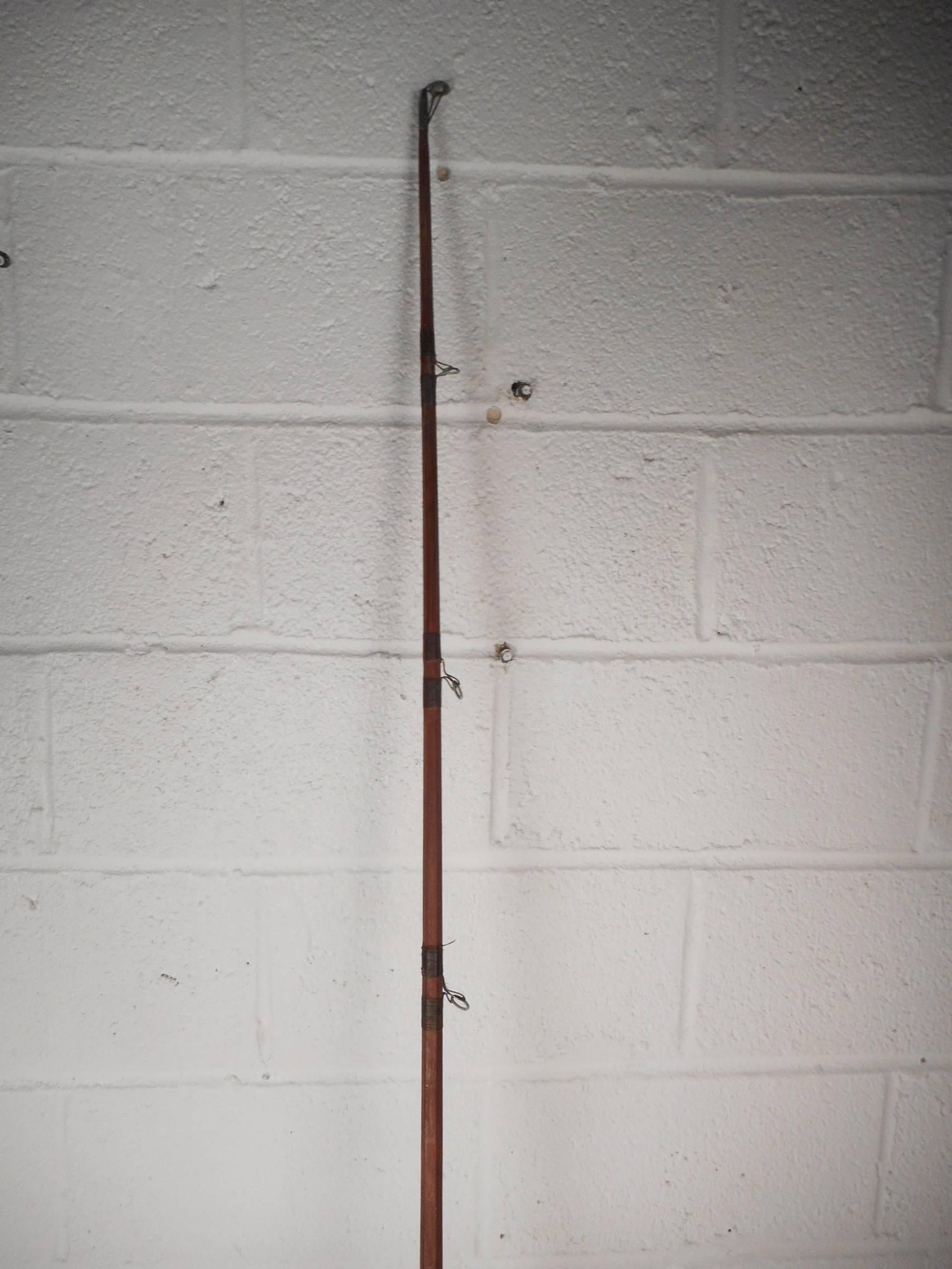 This wonderful vintage fishing pole has a heavy brass rig with a blonde wood handle on the crank. Quality craftsmanship with a wooden grip and a sturdy pole. This gorgeous nautical decorative piece looks great hanging on the wall in any home,