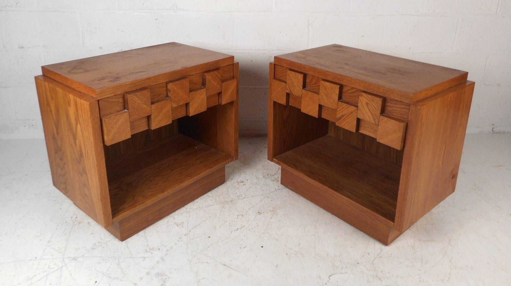 This gorgeous pair of vintage modern nightstands feature one hefty drawer with a large open compartment underneath. Sleek design with a unique Brutalist front and a raised tabletop. This fabulous pair of midcentury end tables make the perfect