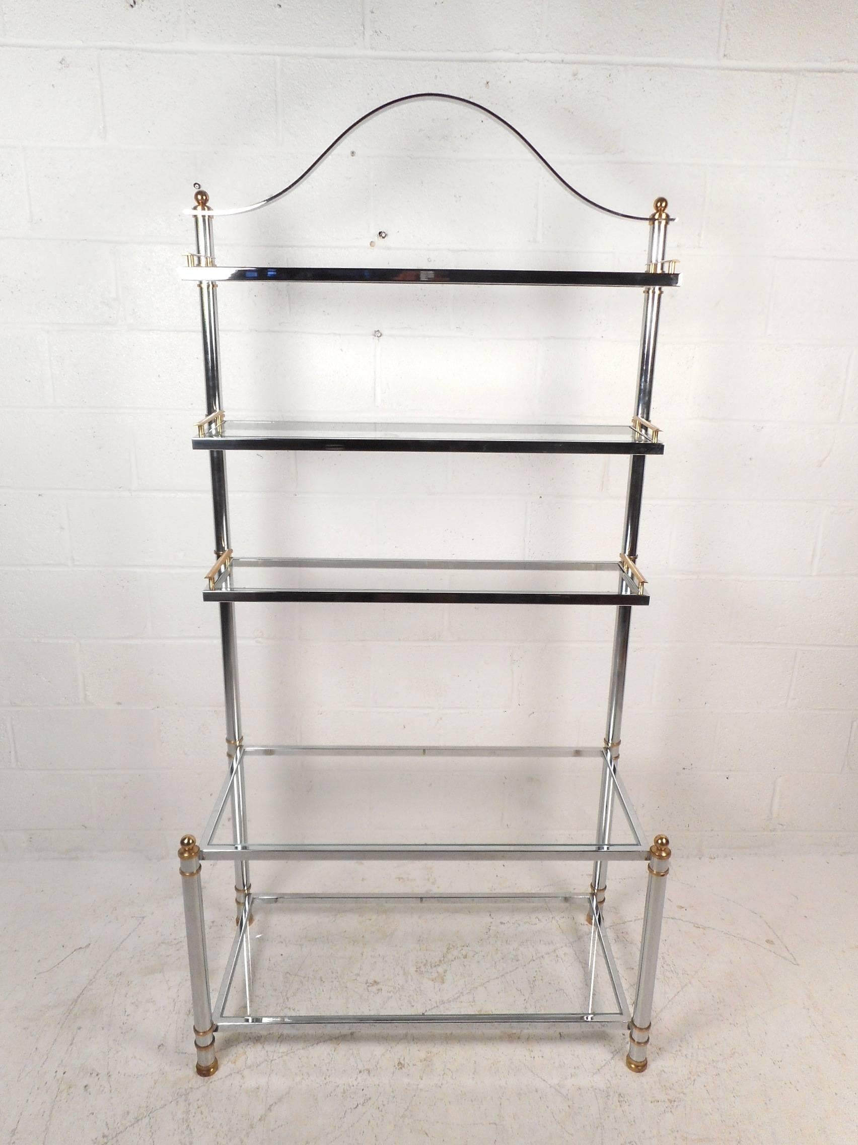 This beautiful vintage modern bakers rack features a chrome tubular frame with brass fixtures. Sleek design with five large glass shelves and a unique arch design on top adding to the allure. The top three shelves have sculpted brass fixtures on