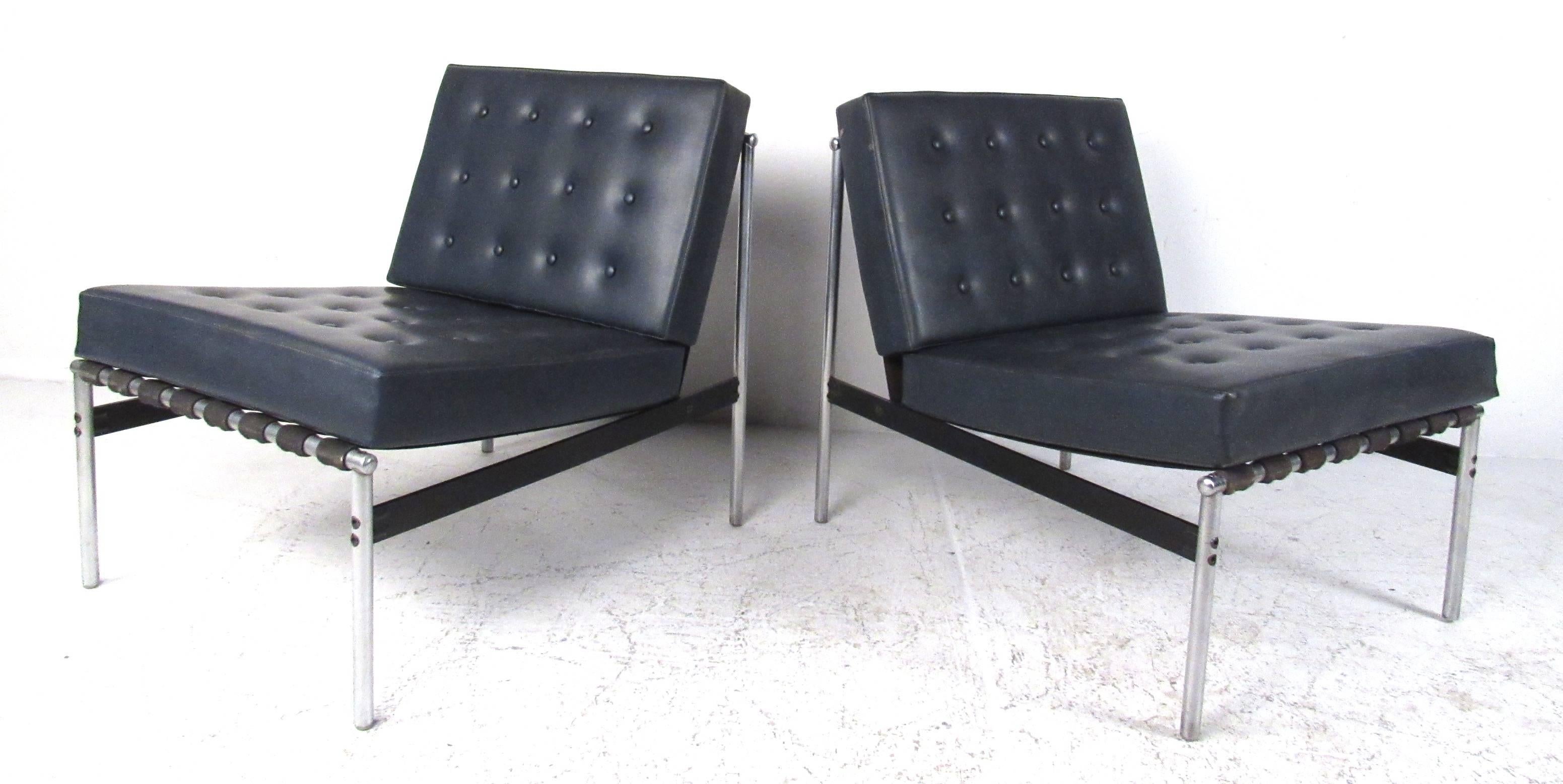 Paire de fauteuils en vinyle touffeté de style bar parallèle dans le style de Florence Knoll. Style moderne du milieu du siècle avec des coussins en vinyle noir soutenus par des cadres tubulaires en aluminium et des sangles tissées. 
Veuillez