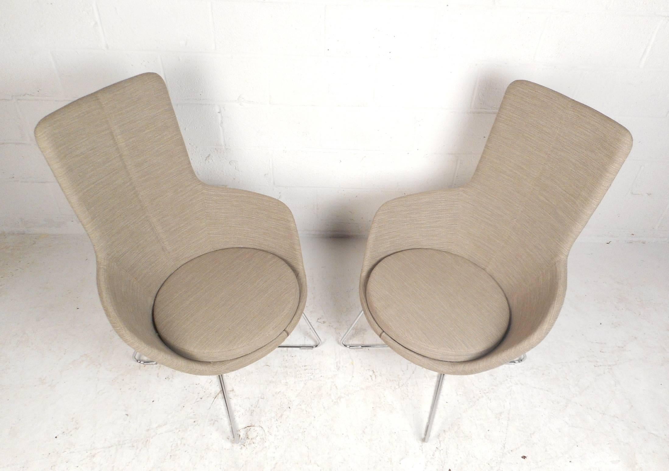 This gorgeous pair of contemporary modern lounge chairs feature unique metal rod bases with hairpin style feet. Unique design with bucket seats, a sculpted high backrest, and a thick padded cushion to sit on. This comfortable pair is covered in