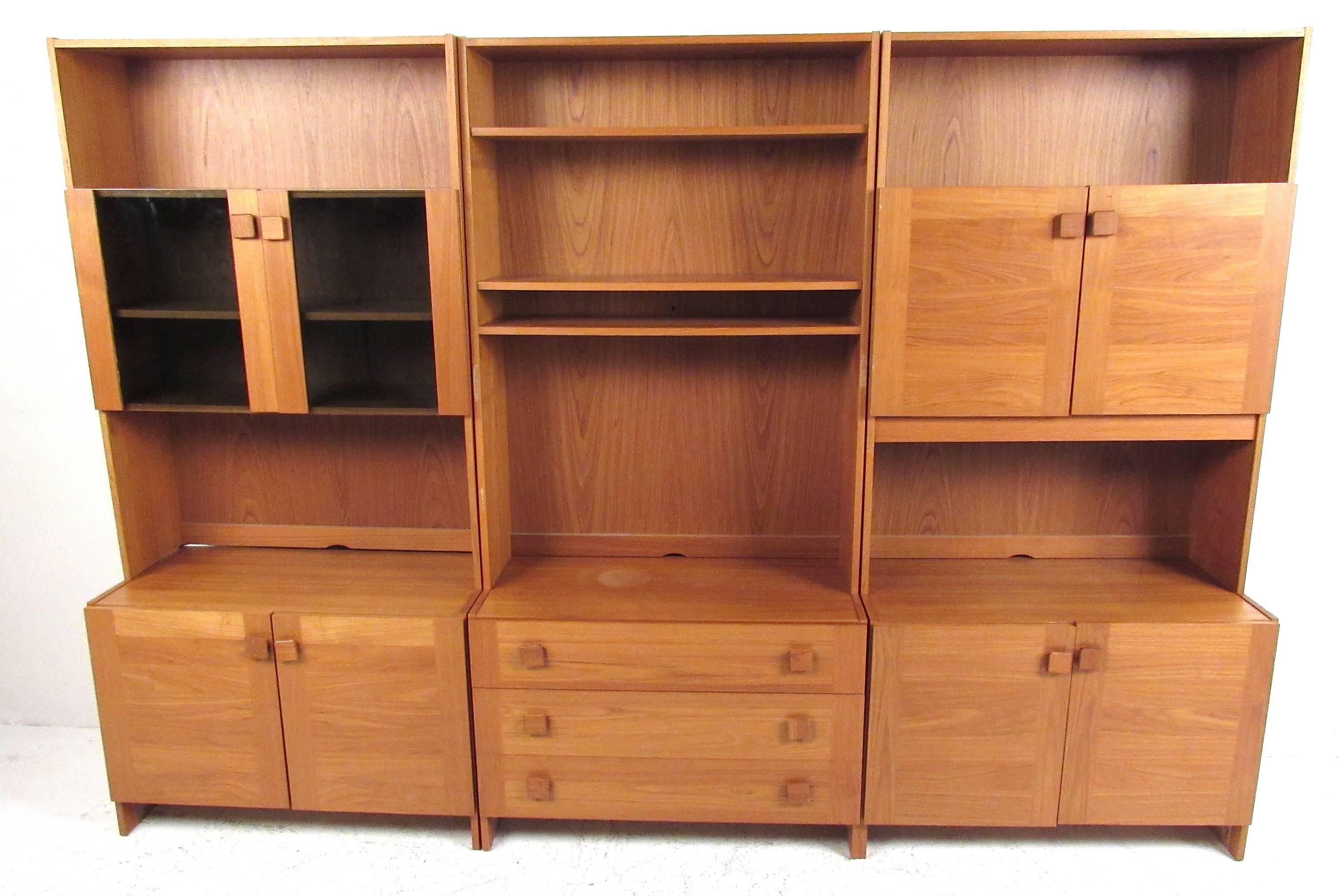 Impressive freestanding teak modular wall unit providing multiple storage and configuration options. The three base and upper cabinets can be arranged as shown or as individual stand alone units, and are also interchangeable enabling maximum