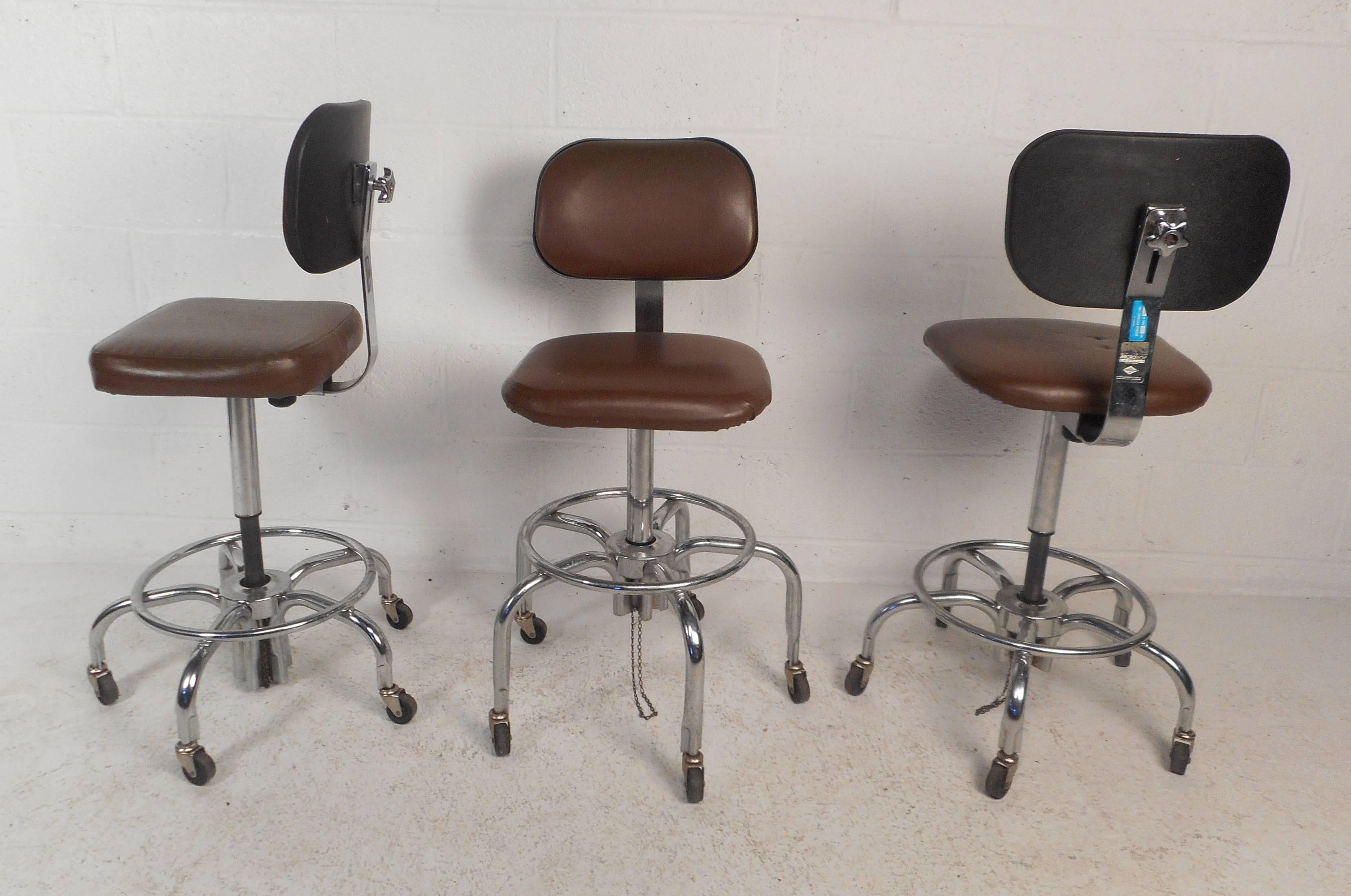Gorgeous set of three vintage modern bar stools with unique bent rod chrome bases and thick padded seats covered in dark brown vinyl. Sleek design ensures plenty of comfort with its high padded backrest and convenient adjustable frame. This