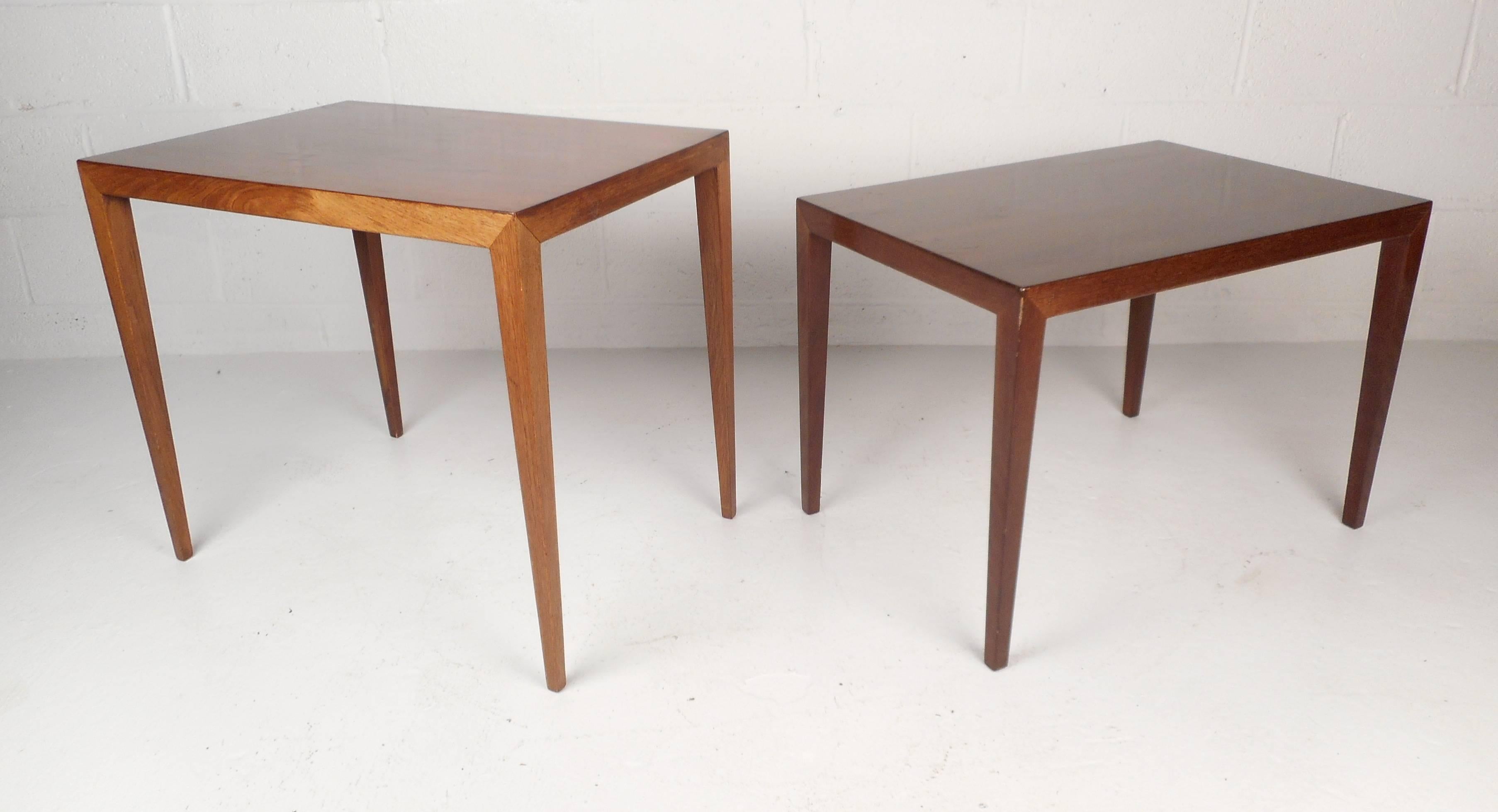 This beautiful pair of vintage modern side tables feature long tapered legs and a rectangular top. Two end tables with unusual slender legs an elegant wood grain throughout. This unique mid-century pair makes the perfect addition to any modern