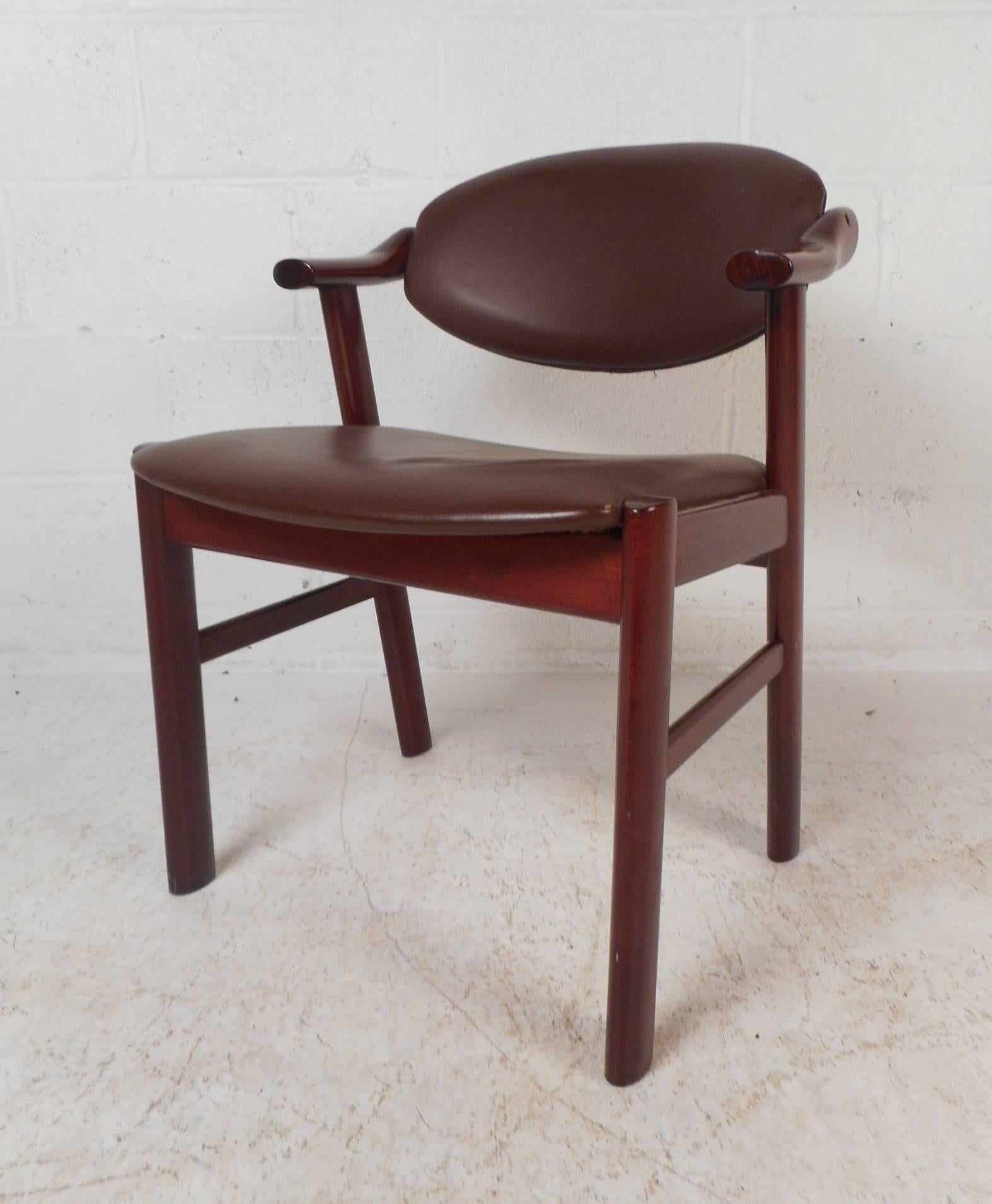 This lovely set of four vintage modern dining chairs feature angled back legs and high arm rests. Sleek design with a back rest that partially swivels to adjust to your back. Elegant dark wood grain on this solid and sculpted frame show quality