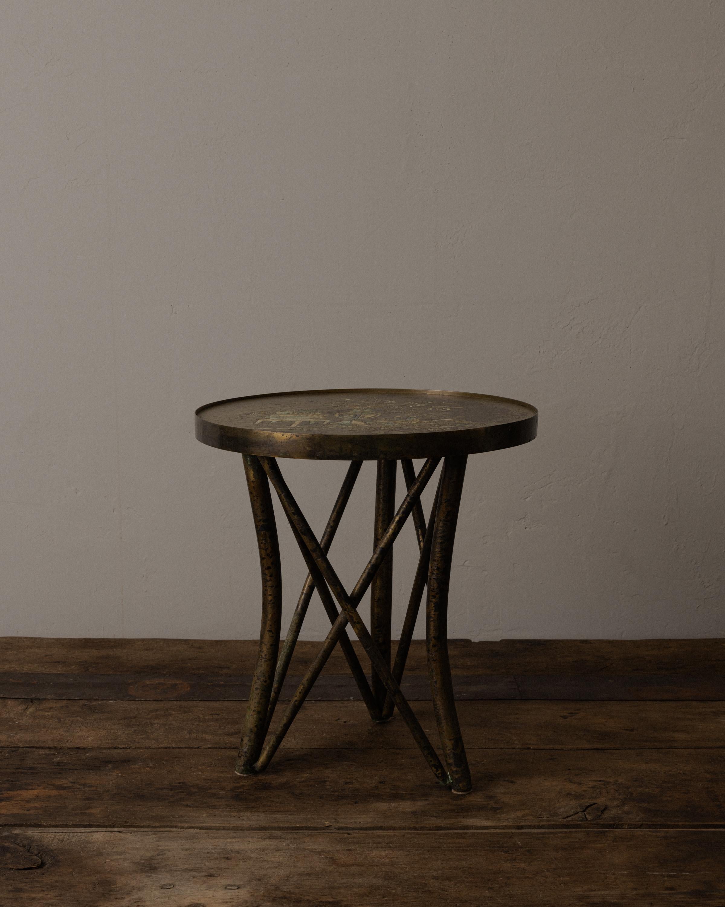 A striking side table by Philip and Kelvin LaVerne, featuring a hand-etched and patinated bronze top with intricate chinoiserie motifs, including vases, foliage, and architectural elements rendered in enamel-accented detail. The richly aged surface