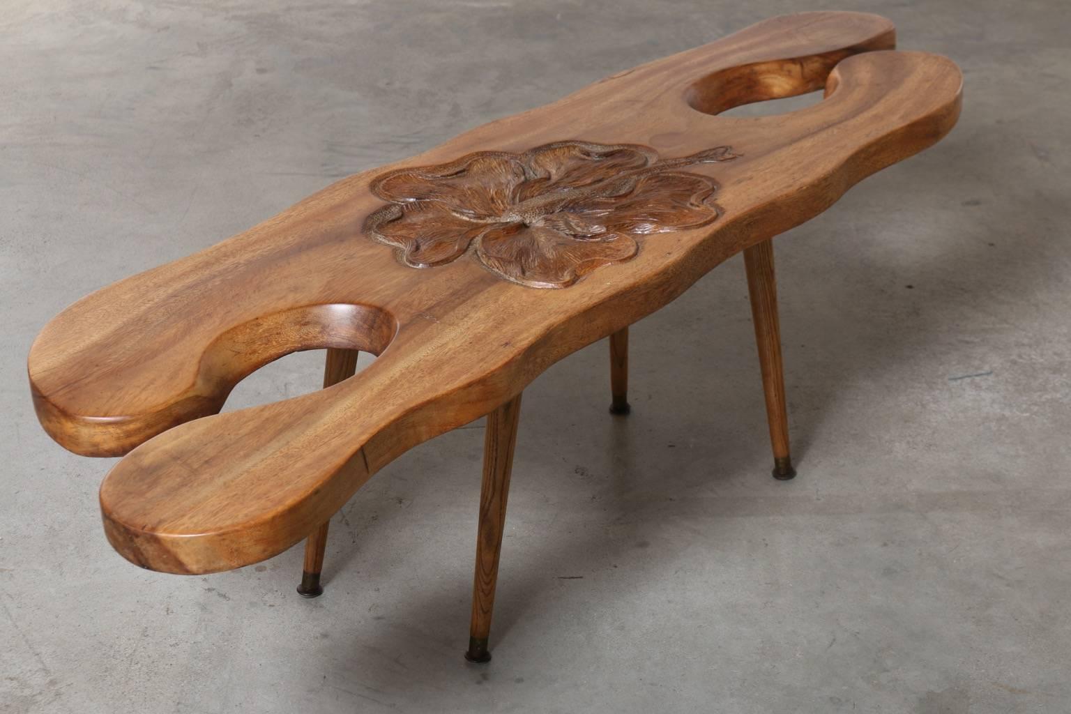 Hawaiian Wood Coffee Table with Hibiscus Flower Carving, circa 1940 
This coffee table features a solid, 2 inch thick, wooden top with stunning grain pattern and a large, intricate hibiscus flower carving in the center. The H shape of the table adds