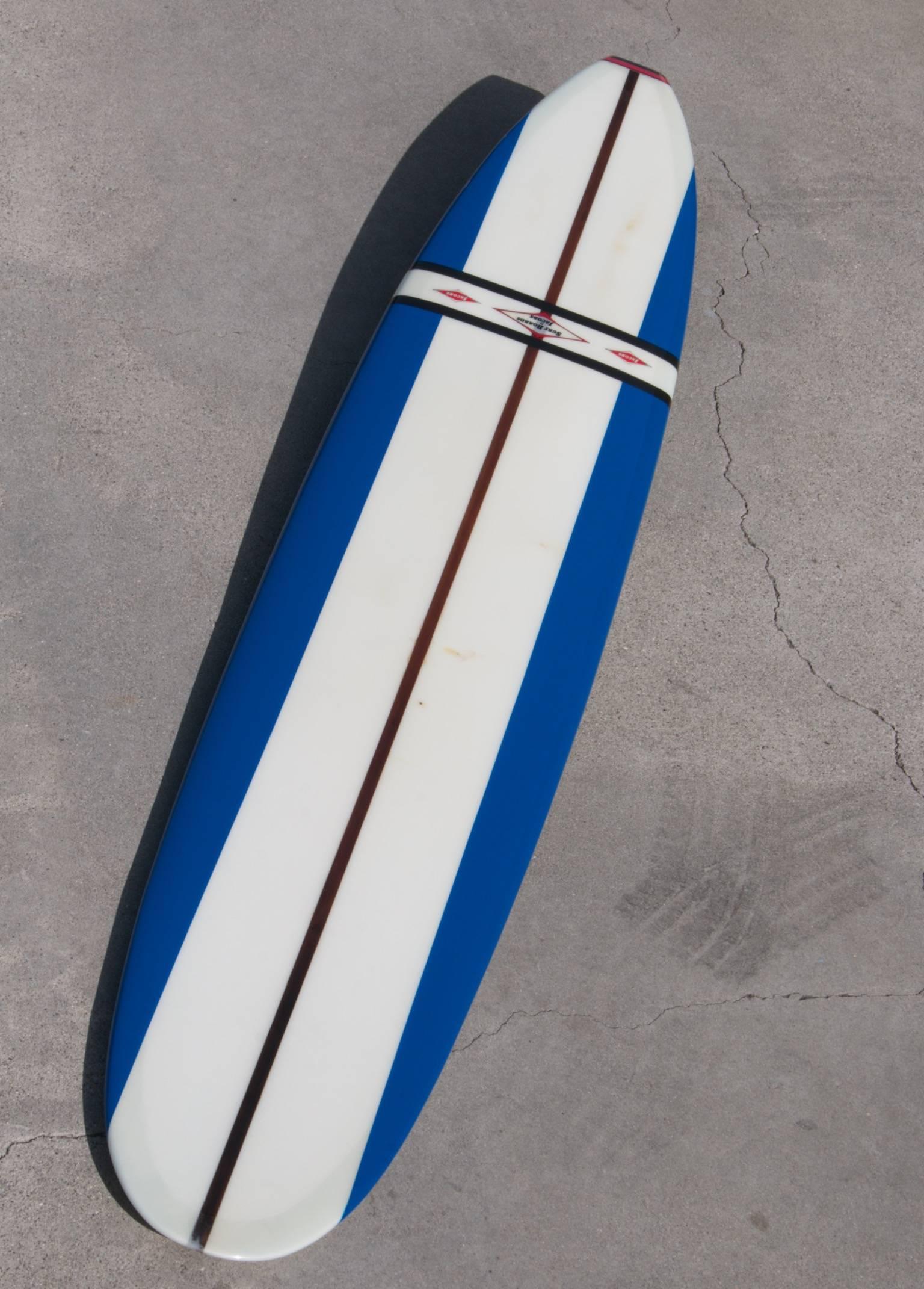 Jacobs surfboard fully restored, blue, white and red, early 1960s.

This majestic early 1960s surfboard has been fully restored, is a real eye-catcher and a board that any collector would be proud to display. The three logos, black competition