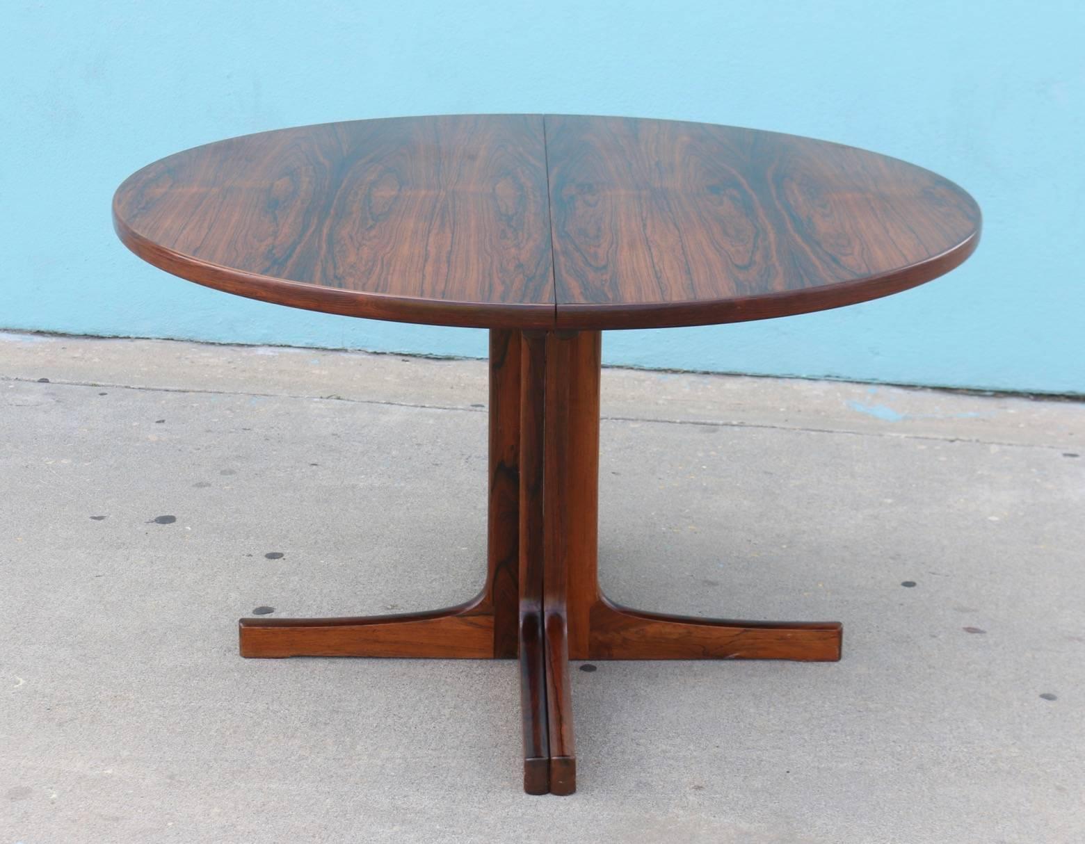 1970s Danish dining table with two leaves made of rosewood, solid, beautiful and adjustable round to oval. 

Measures: 48 inches diameter x 29 inches high, extends to 96 inches (each leaf is 24 inches wide).