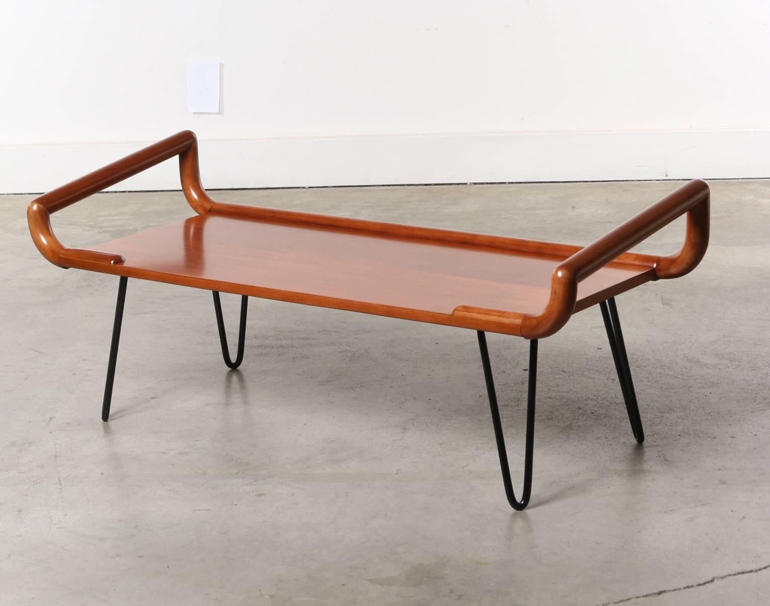 Unique form and quality craftsmanship are combined in this multi functional bench. Solidly supported by metal hairpin legs this piece has handles that would border a cushion or blanket, a perfect entry way, occasional bench or bottom of the bed