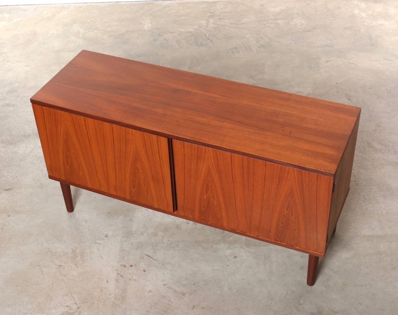 Hans Olson teak credenza cabinet. Made of stunning teakwood. Low profile, with doors that swing open wide revealing removable shelves. Plenty of interior storage for records, entertainment systems, books, blankets and more. Very sturdy and in very