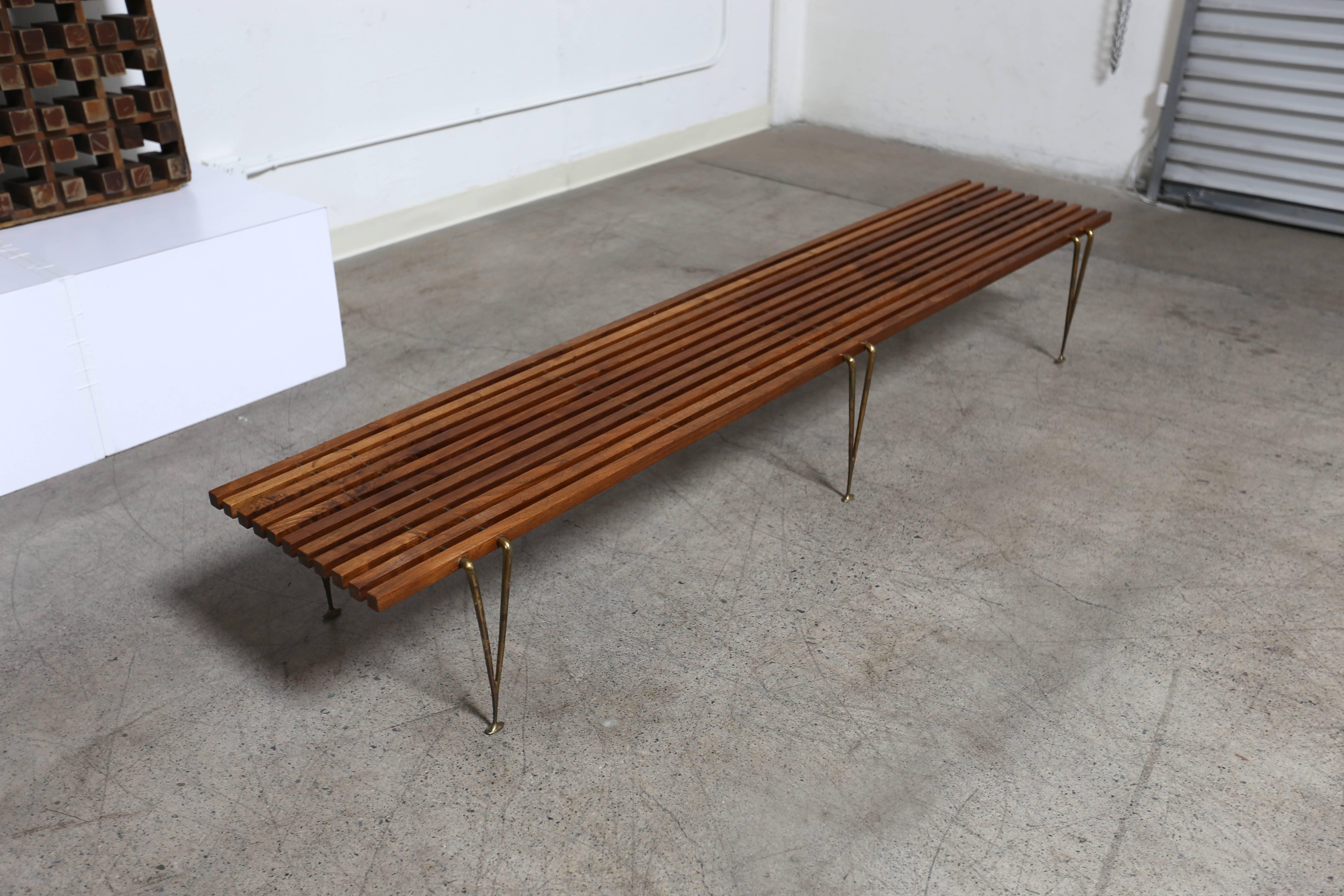 Long walnut and brass slat bench or coffee table by Hugh Acton.