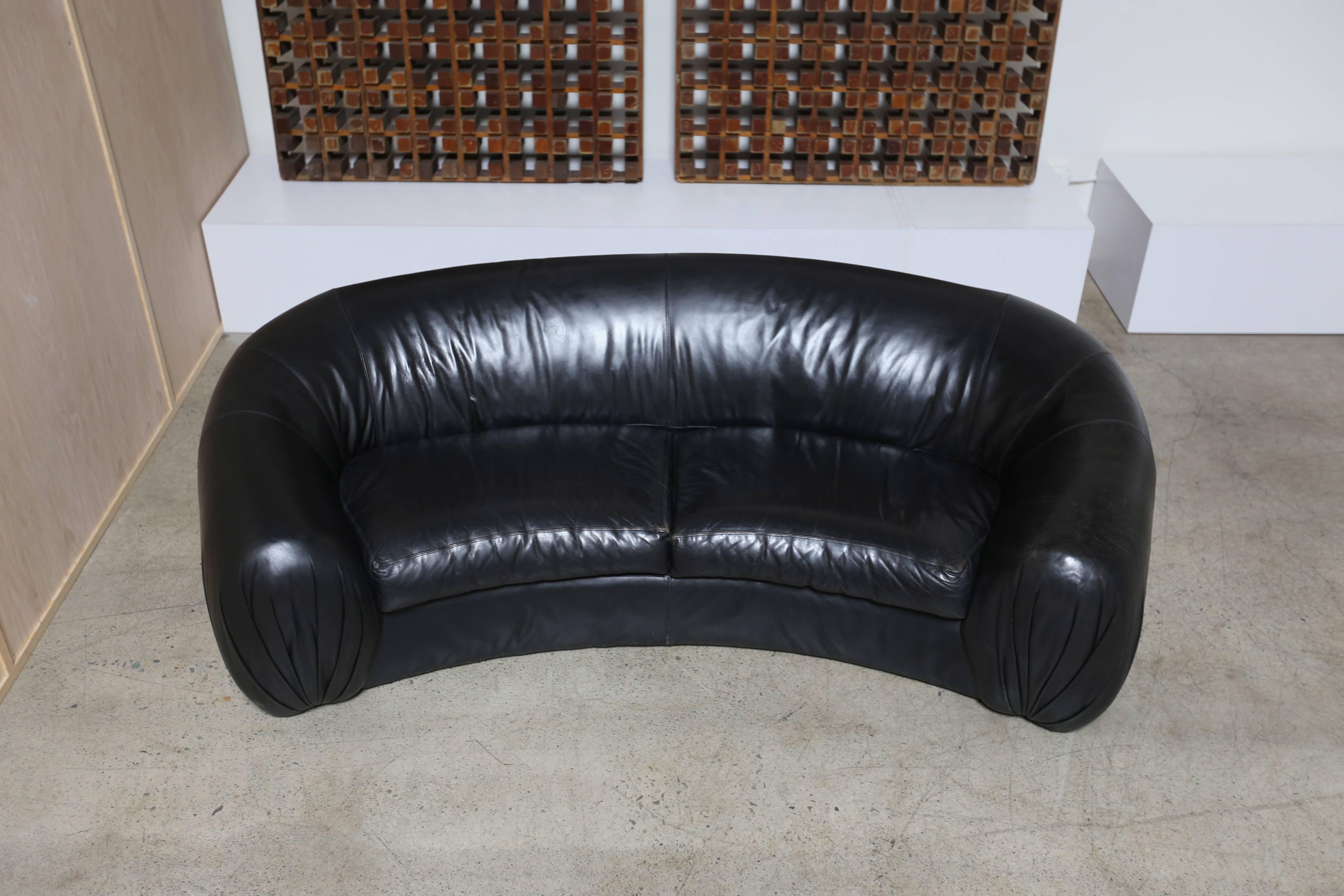 Curved black leather sofa by Directional Furniture Company.