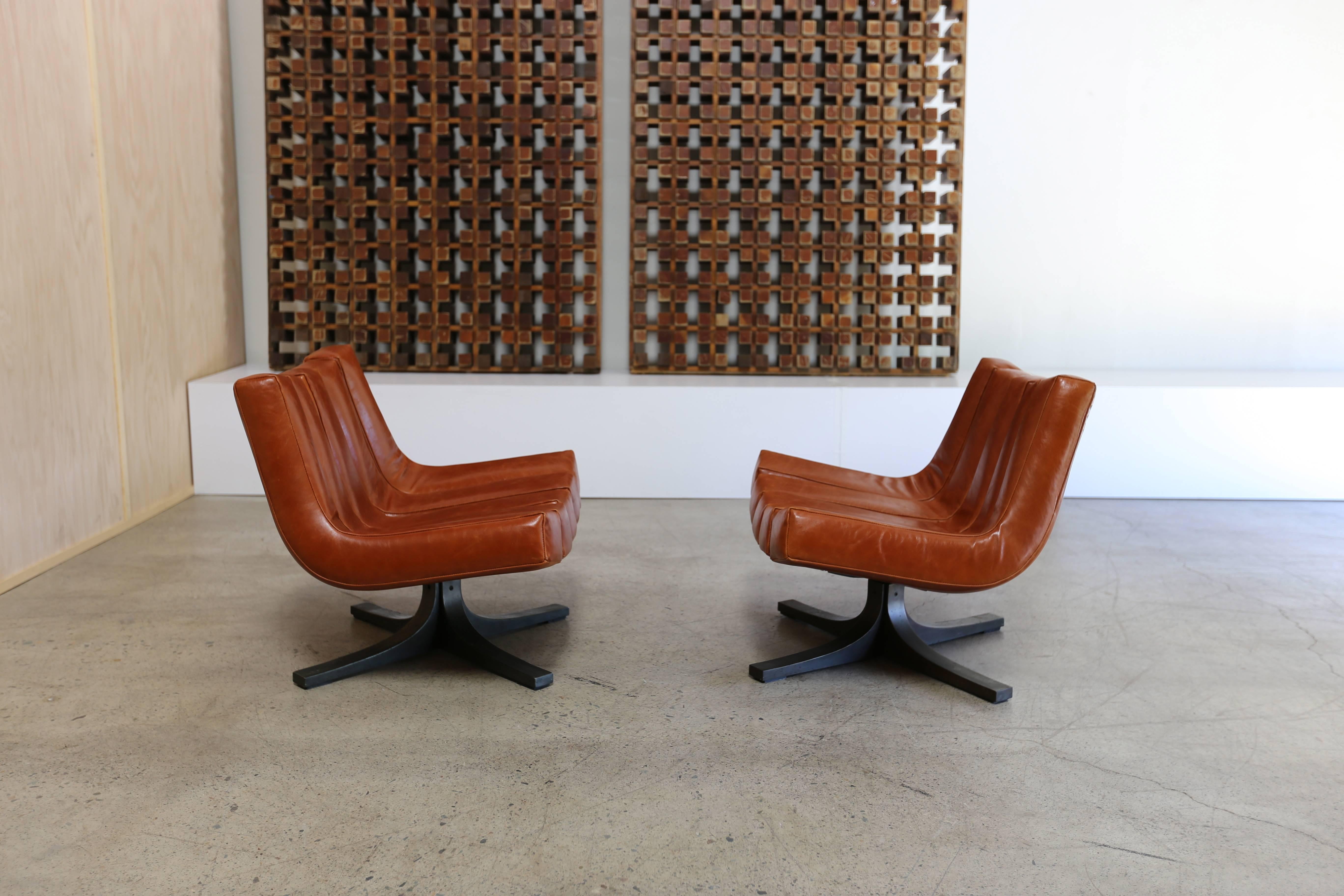 Pair of Swivel lounge chairs by Javier Carvajal. Spain 1972. Leather with bronze-plated steel bases.