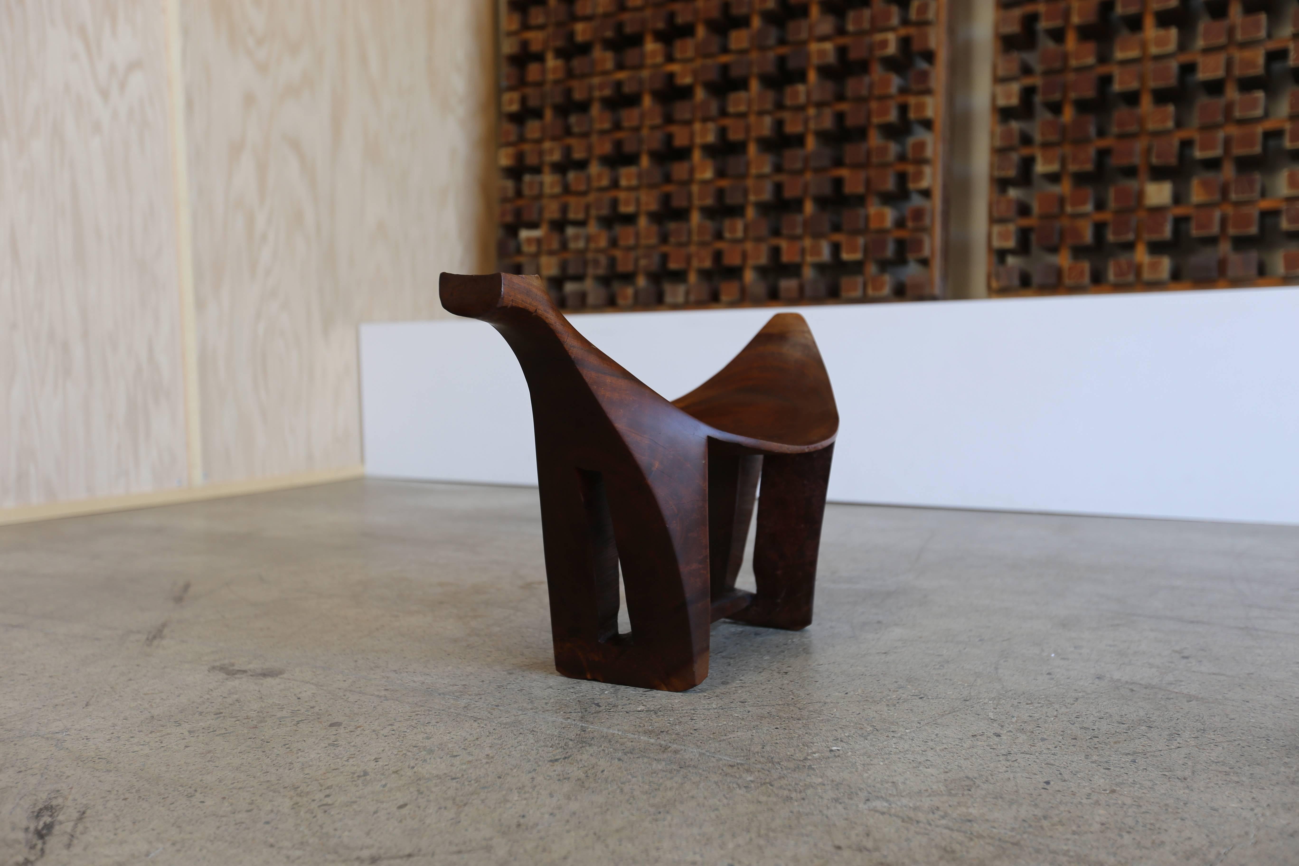 Hand-carved sculptural wood stool. 

Provenance: The estate of Tom Tramel.