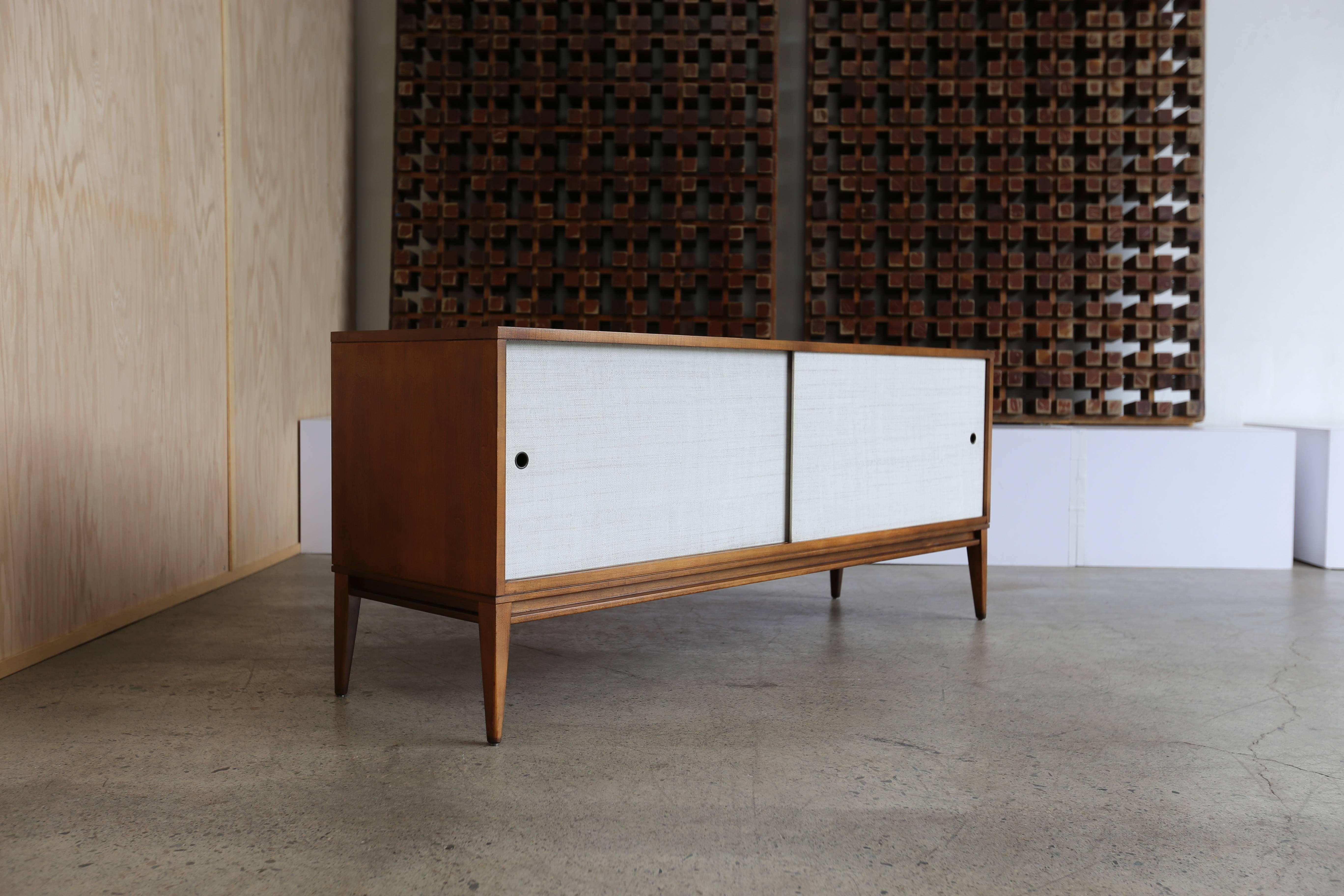 Credenza by Paul McCobb for Planner Group. Two adjustable shelves behind sliding doors. Very nice original condition with only minor wear. Perfect scale for a media stand.