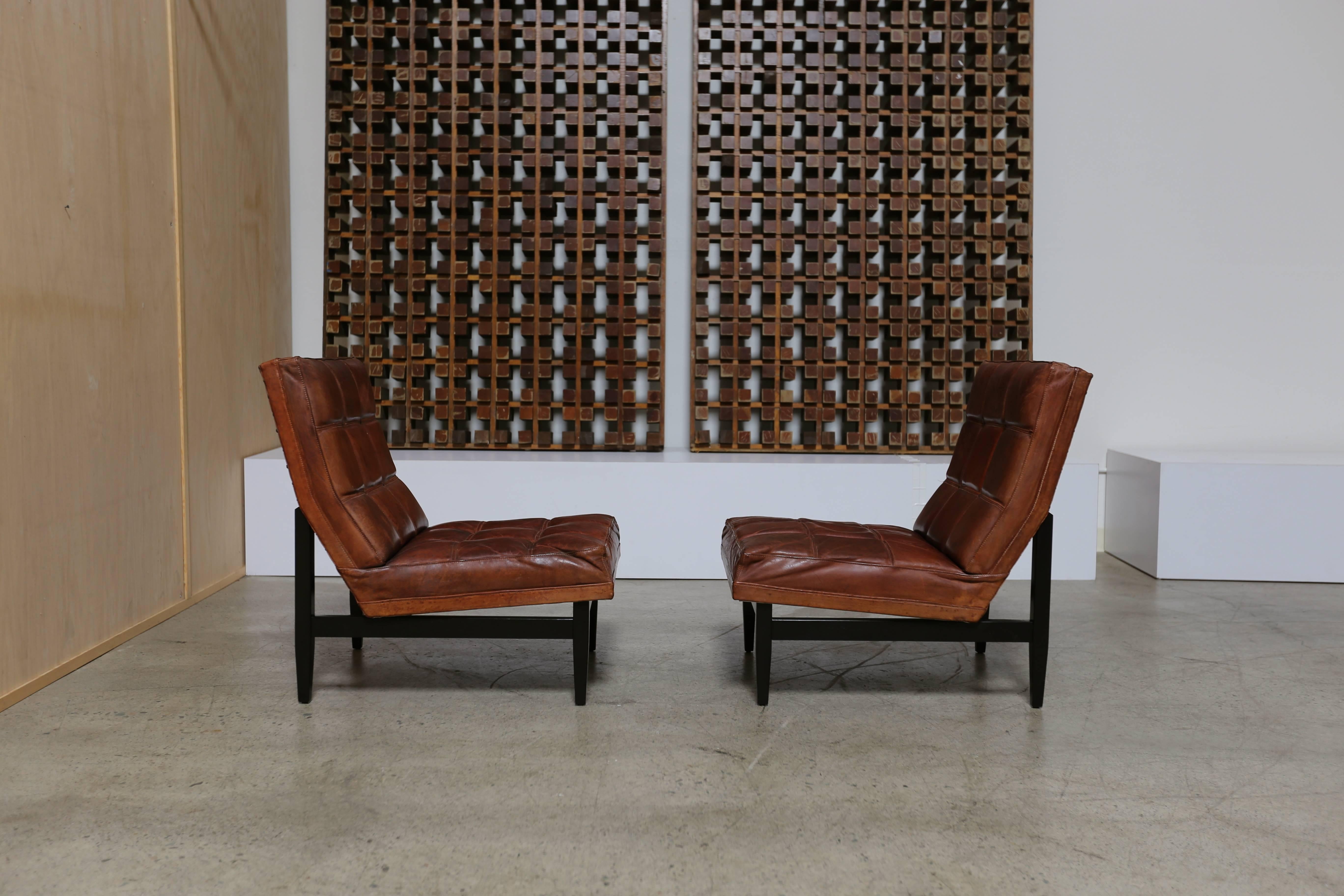 Pair of box stitched leather lounge chairs by Camacho Roldan & Artecto Colombia. Beautiful patina to the original leather. We have a matching sofa on another listing.