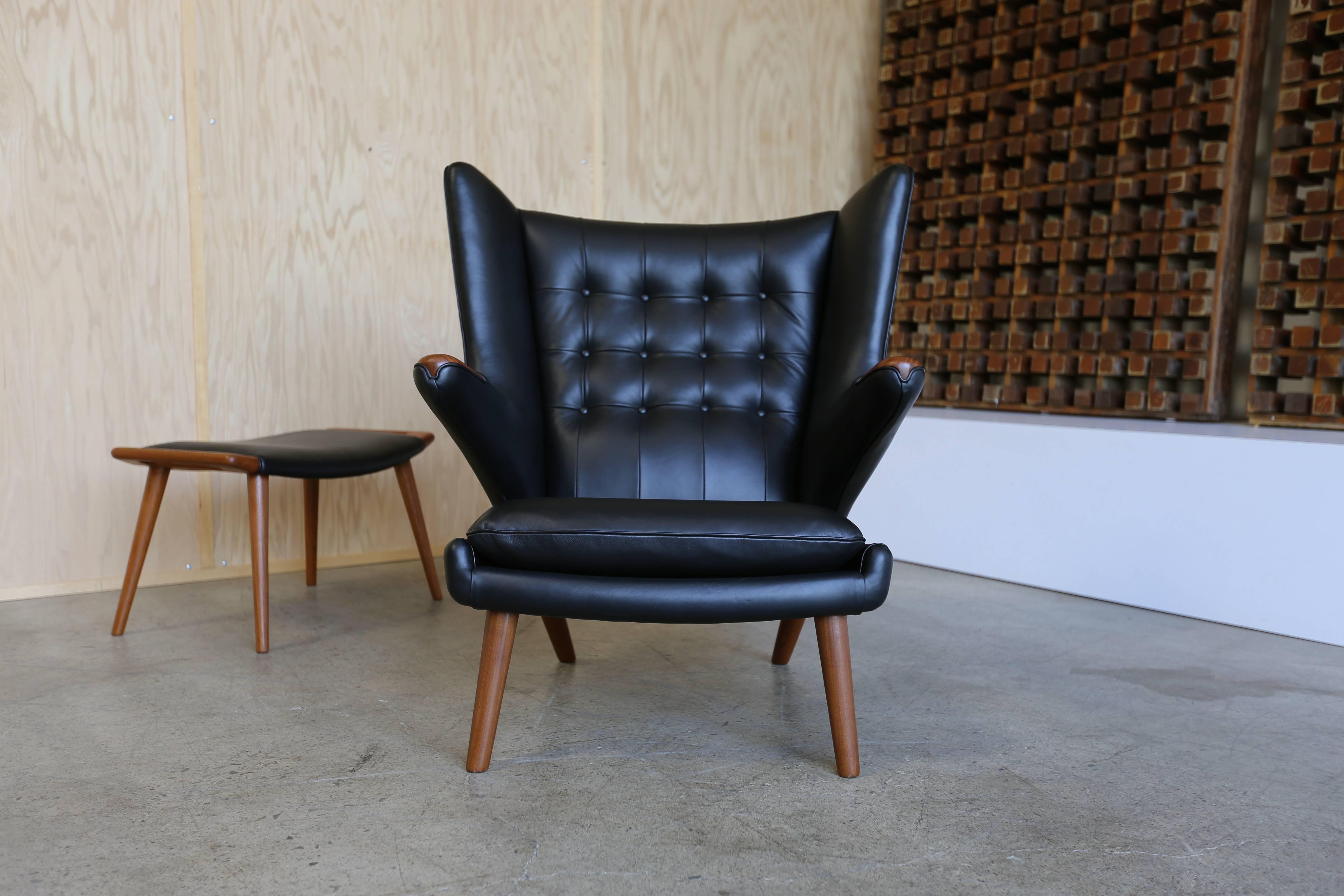 Black leather Papa Bear chair and ottoman by Hans Wegner. Manufactured by A.P. Stolen. This piece has been expertly restored and is in excellent condition. Retains the original stamp to the bottom along with the original Danish Control tag.