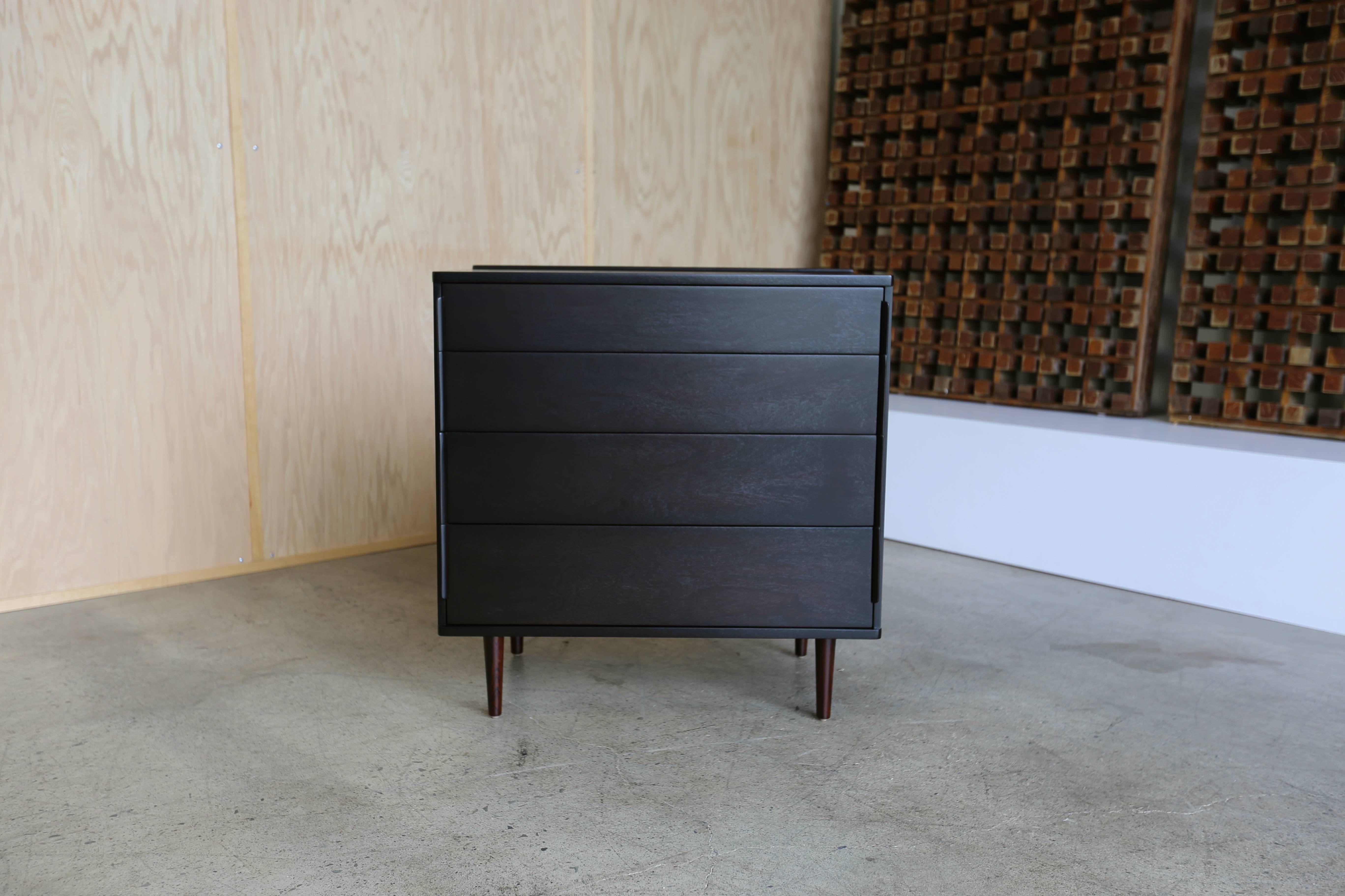 Ebonized four-drawer chest with rosewood legs by Edward Wormley for Dunbar. This piece has been professionally restored.