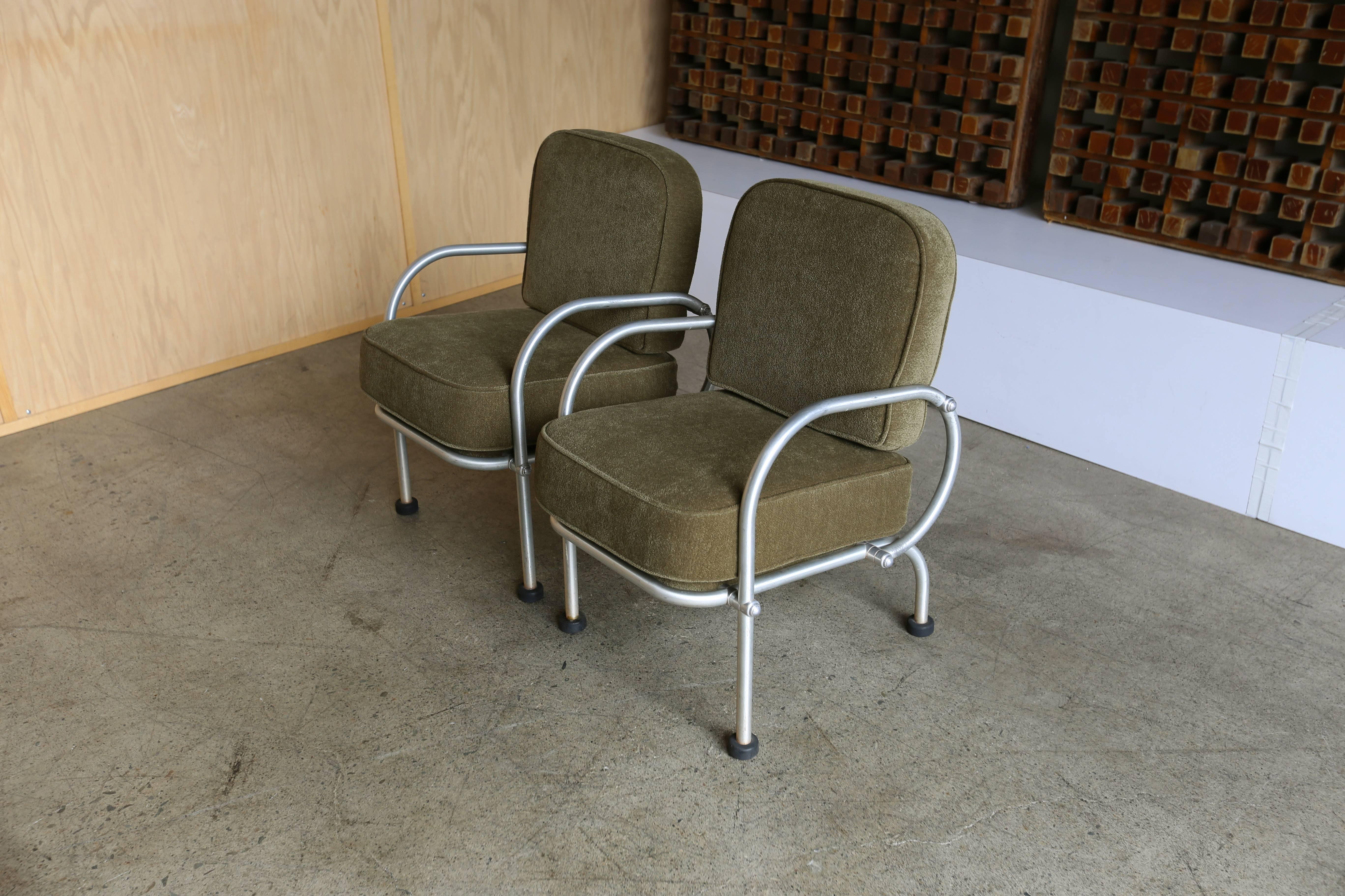 A pair of spun aluminum lounge chairs by Warren McArthur. New Maharam Scout olive upholstery.