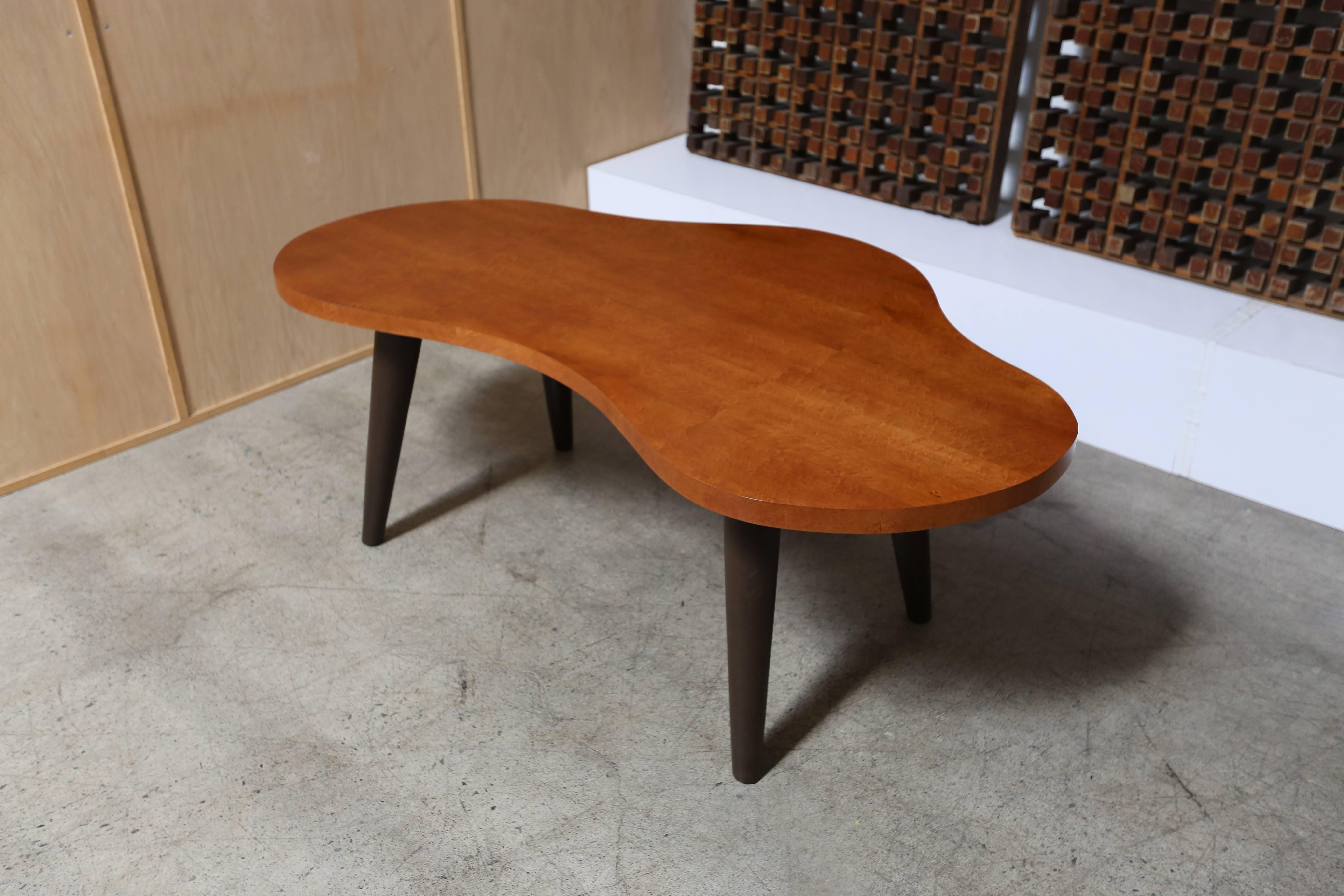 Bird's-eye maple biomorphic desk with leather wrapped legs, circa 1945. The top has been professionally restored.