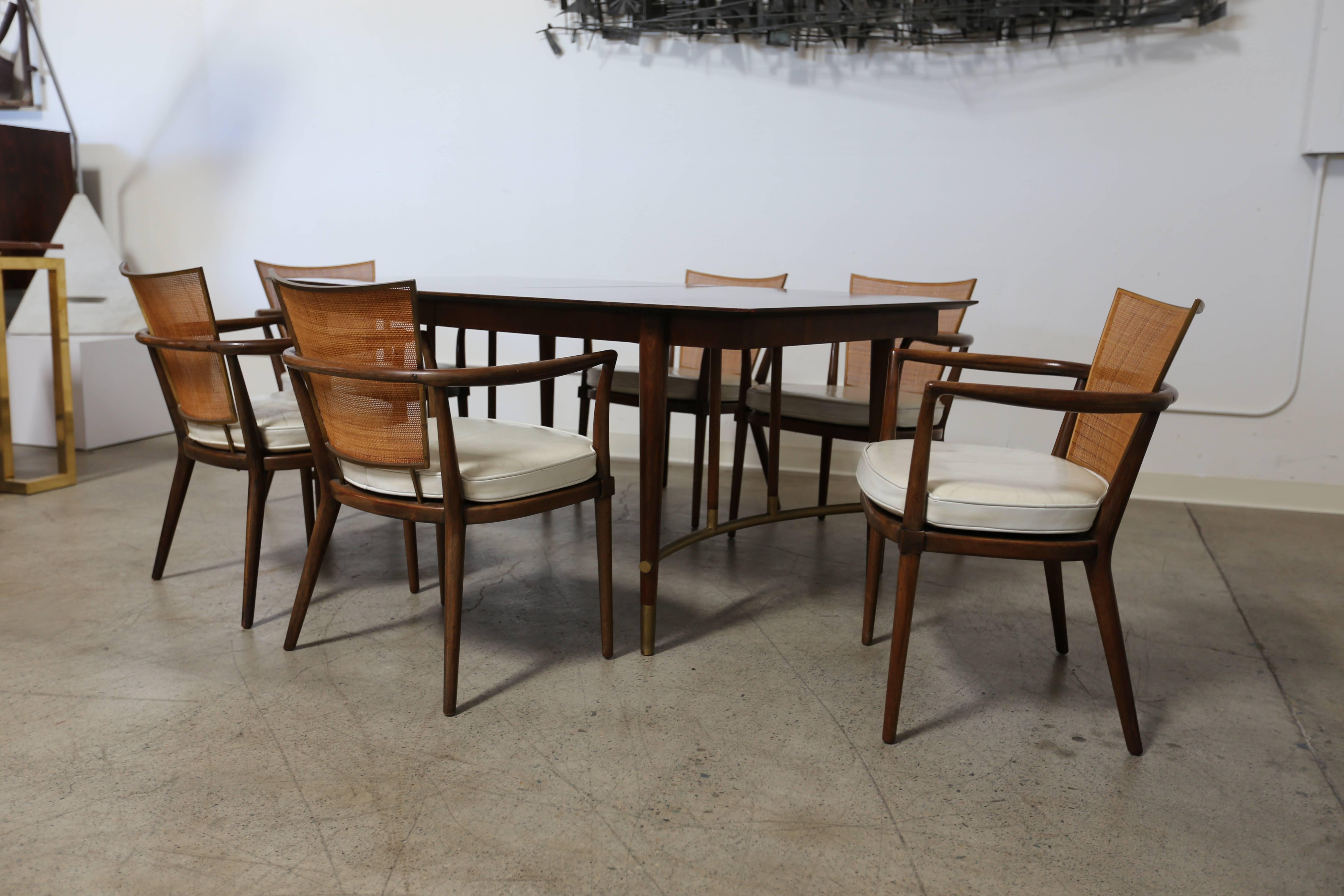 Dining set by Bert England for Johnson Furniture Company. Set of six cane back and leather dining armchairs with dining table. This set retains three additional original leaves.

Each chair measures: 24.5
