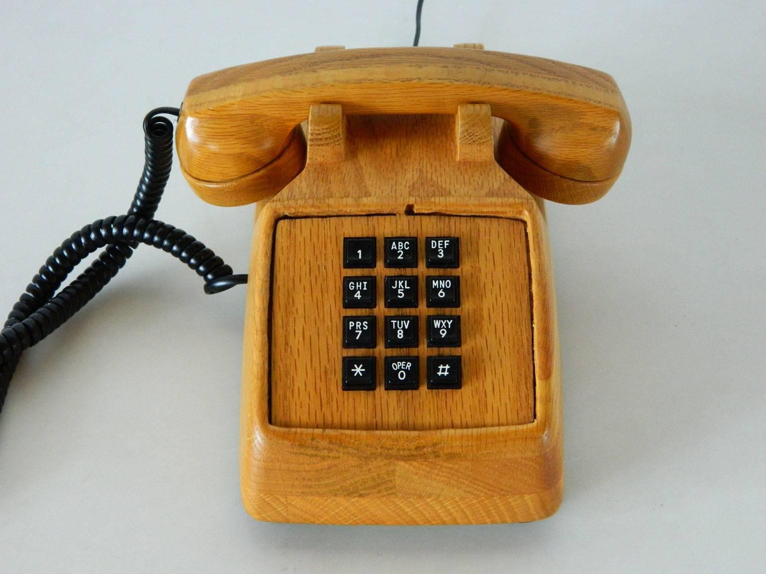 Vintage touch-tone telephone with warm wood harkens back to a time when one had to sit while talking on the phone. Manufactured in 1987, this telephone requires a landline and phone jack.