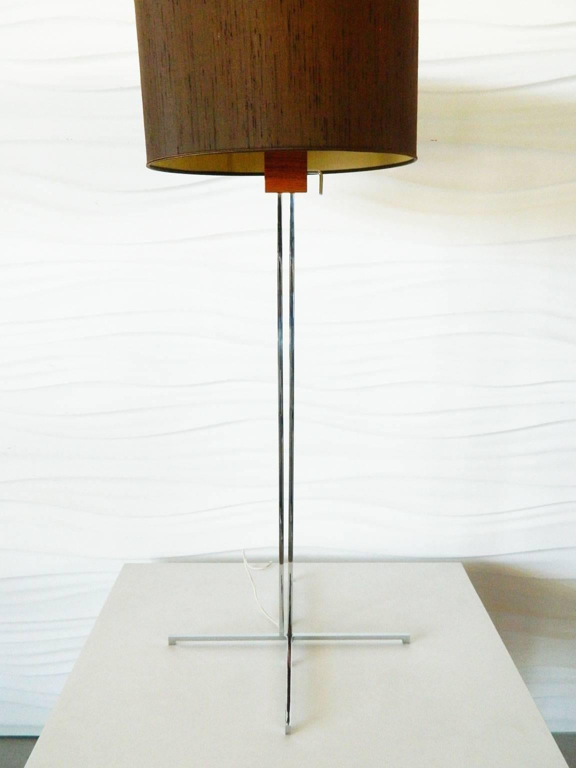This Swiss made adjustable chrome and walnut floor lamp is by Hans Eichenberger. It can vary in height from 42 inches to 78 inches and has three light bulb sockets.