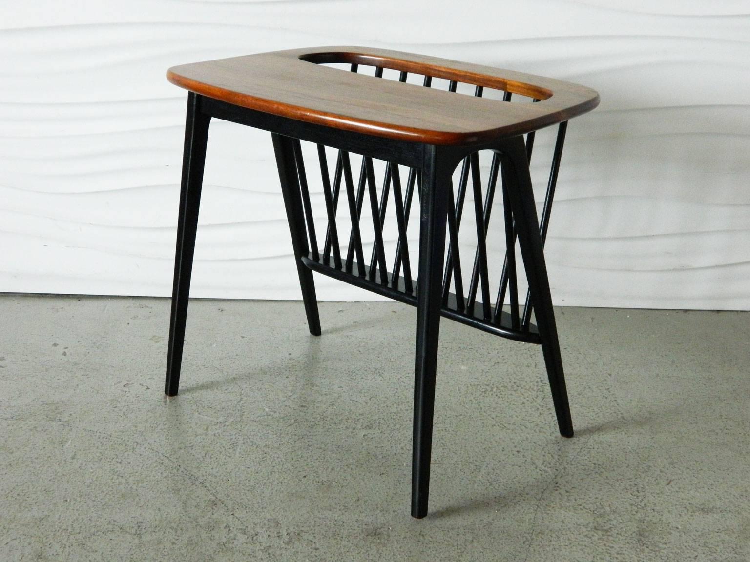 The gorgeous grain of the walnut top contrasts beautifully with the black painted base of this iconic Arthur Umanoff magazine stand or side table.