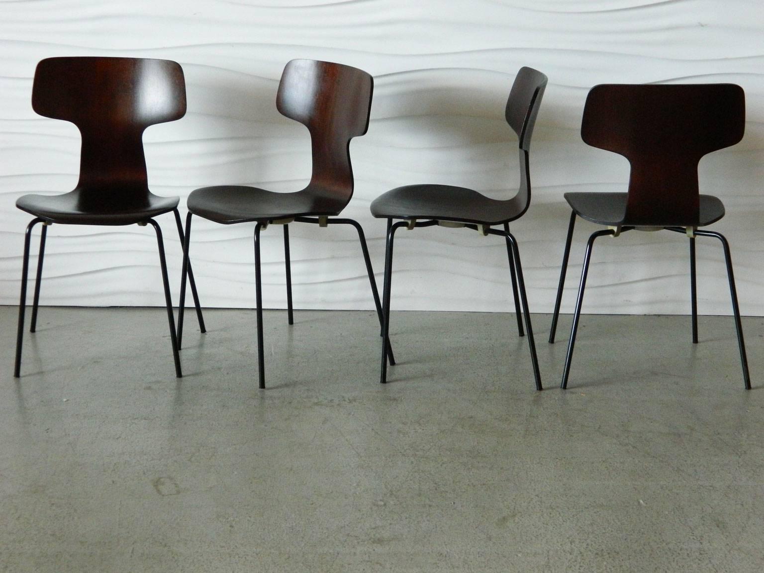 The 3103 chair (also known as the Hammer chair or "T" chair) was designed by Danish designer Arne Jacobsen in 1957 in collaboration with Dr. E. Snorason to improve lumbar support. The chairs have metal frames and the seats are made of
