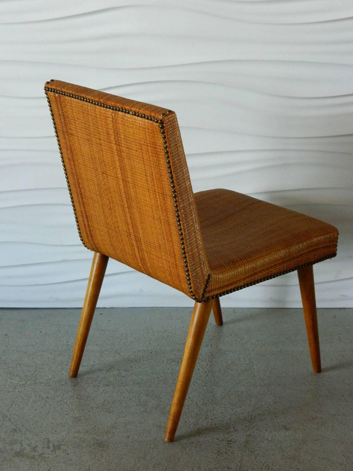 This stylish cane-covered chair by T.H. Robsjohn-Gibbings for Widdicomb has brass nailhead details.
