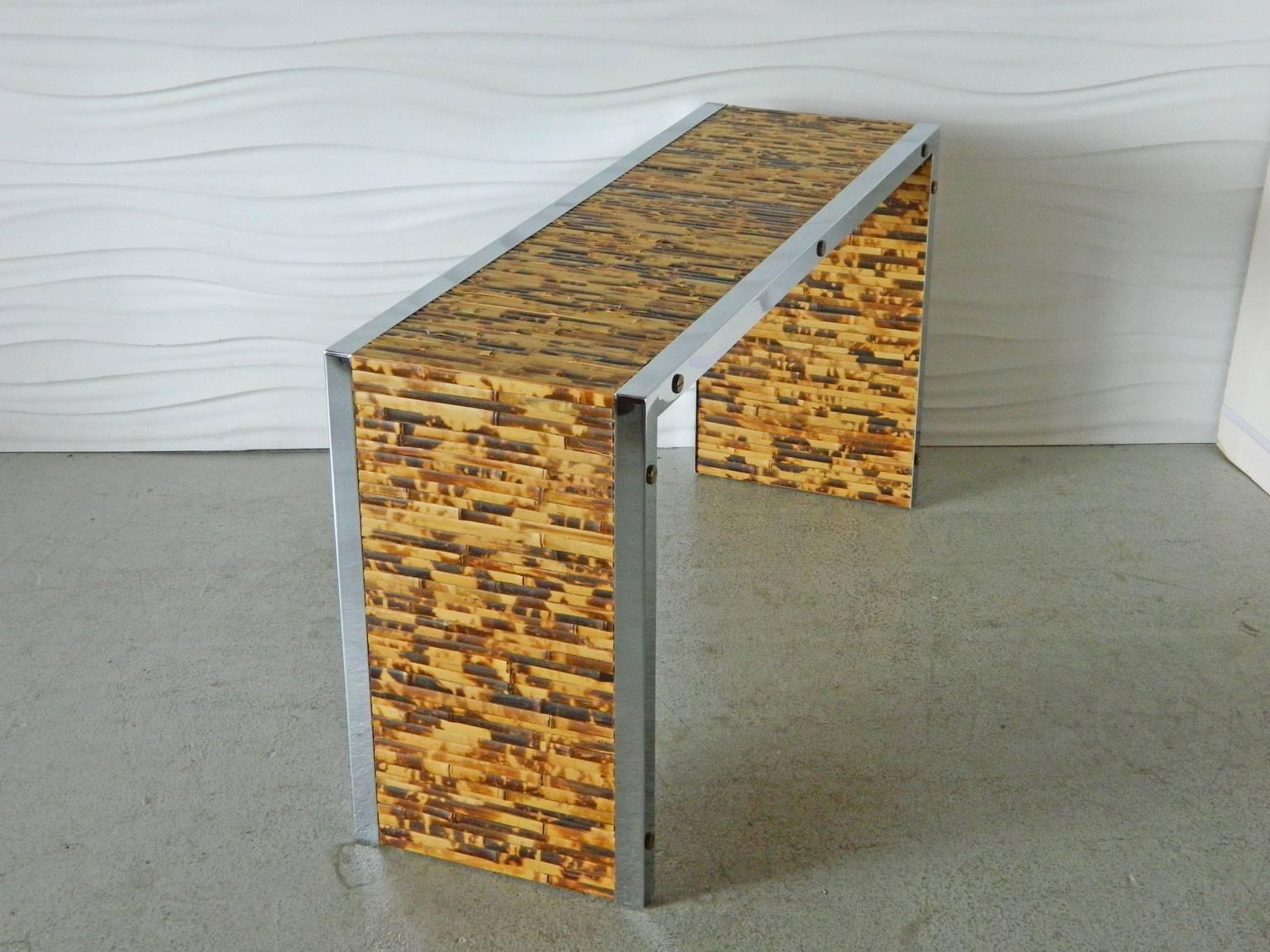 This burnt bamboo console is accented with chrome trim and brass screw heads.