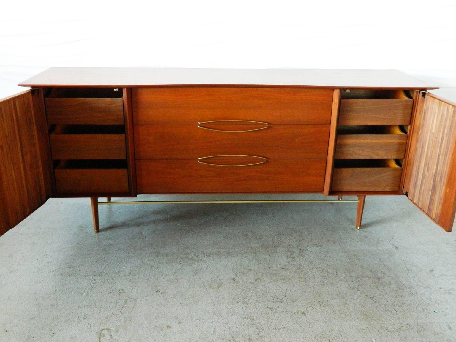 This American Modern sideboard designed by Hobey Helen for Baker Furniture has clean lines and brushed gold handles and details on the legs.