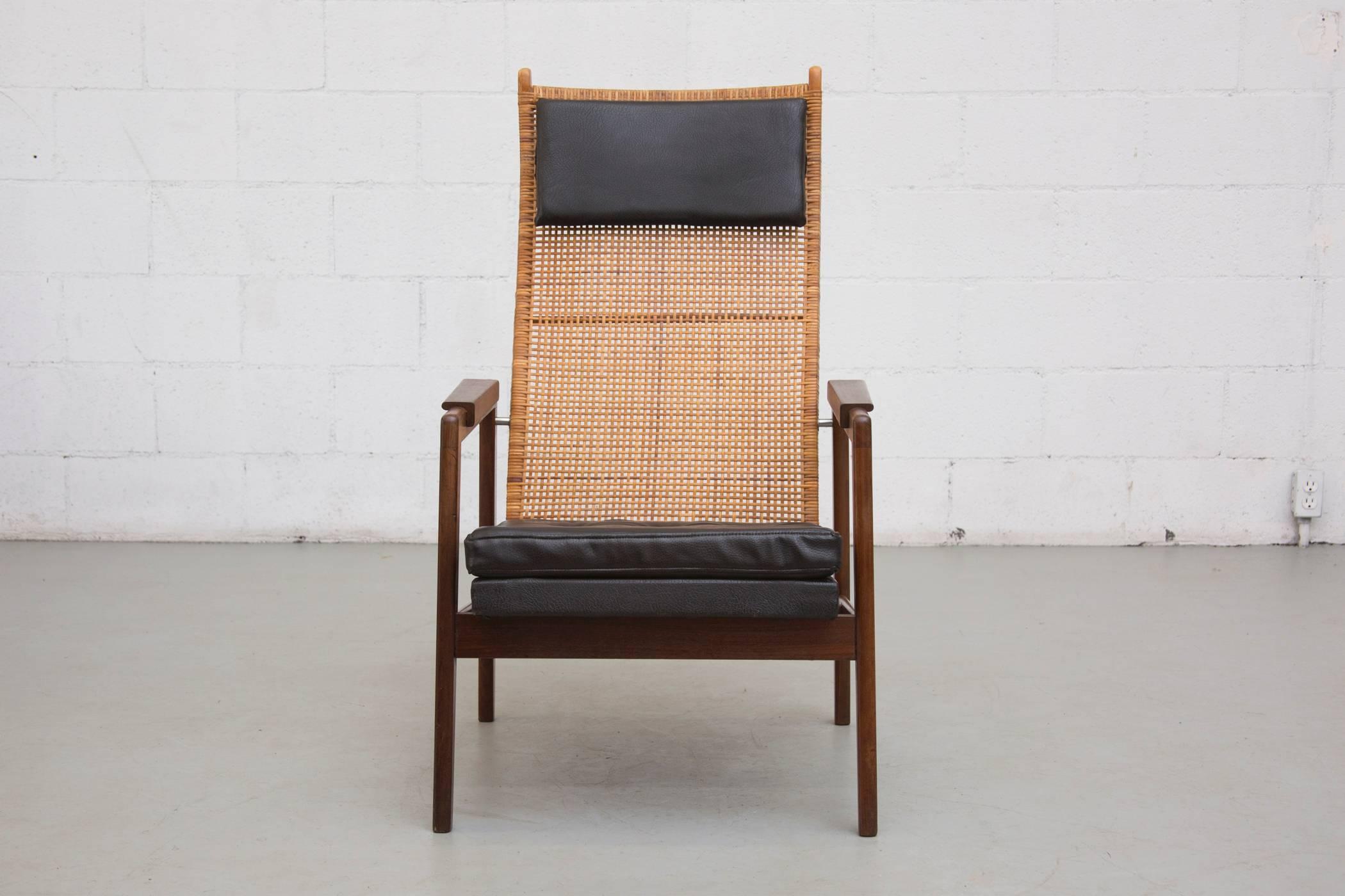 Lounge chair designed by P.J. Muntendam for Gebr. Jonkers in 1956. Beautifully woven rattan back and finished teakwood frame with skai upholstered seat and headrest pillow. Slight rattan loss, original condition.