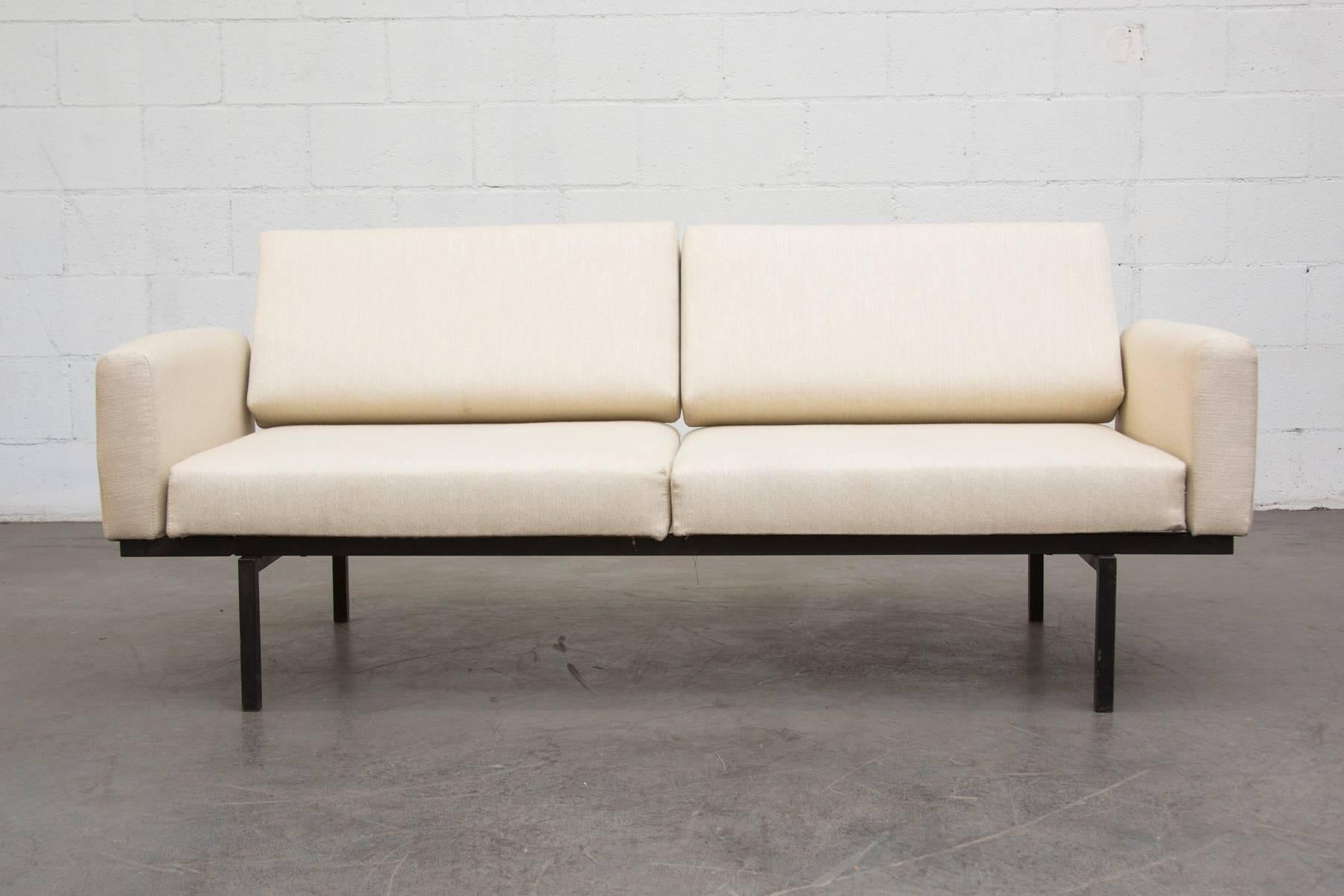 Rare conversion sofa to bed with armrests from Coen de Vries for Pilastro. Newly upholstered cream with black enameled metal frame. When as a daybed it measures 88.25 x 31.75 x 15/26.125. Frame in very original condition with visible signs of wear