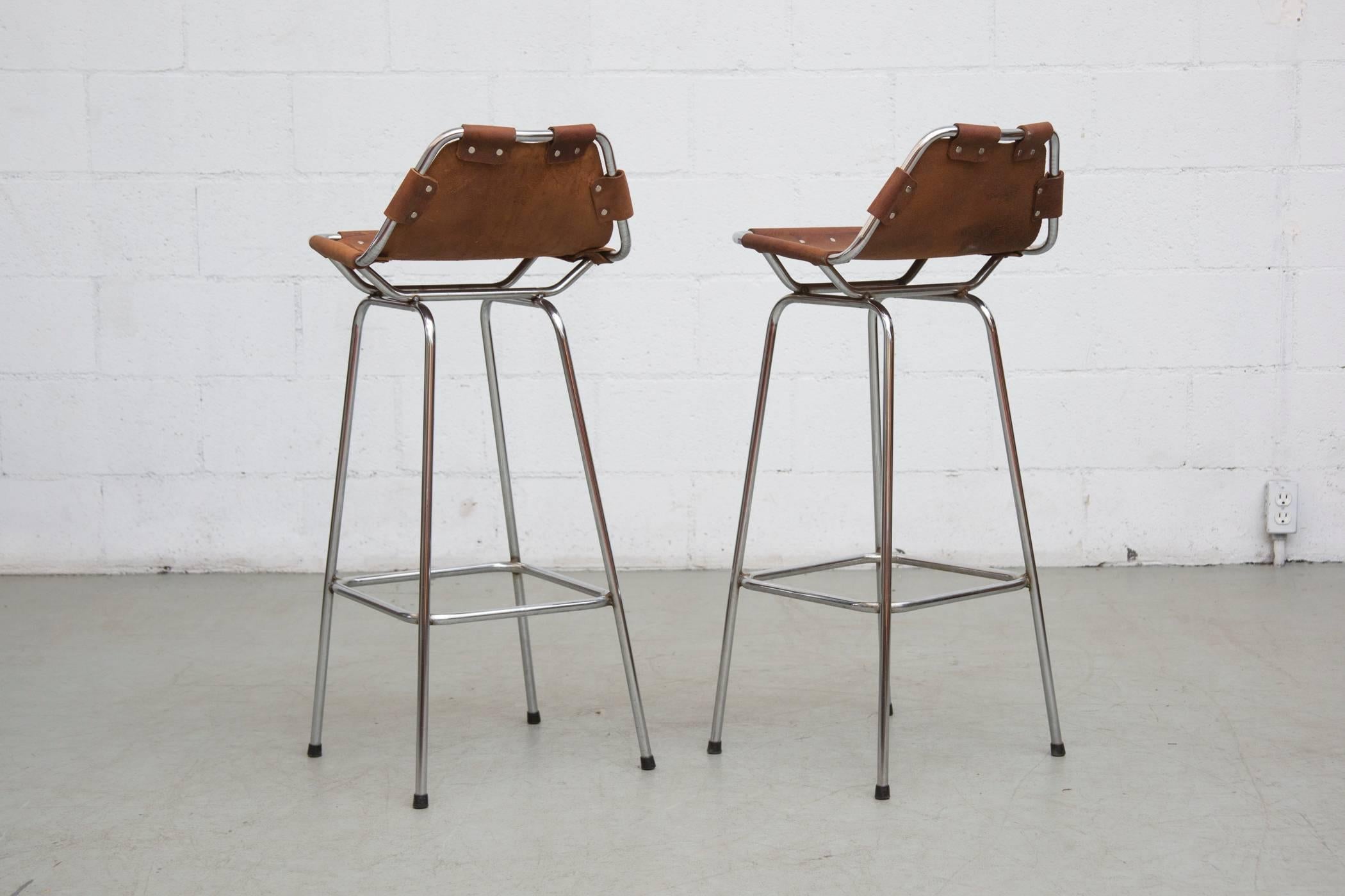 Pair of Perriand style bar stools with chrome frame and new natural leather seating. Chrome in original condition. Some signs of wear and repair. Stunning set.